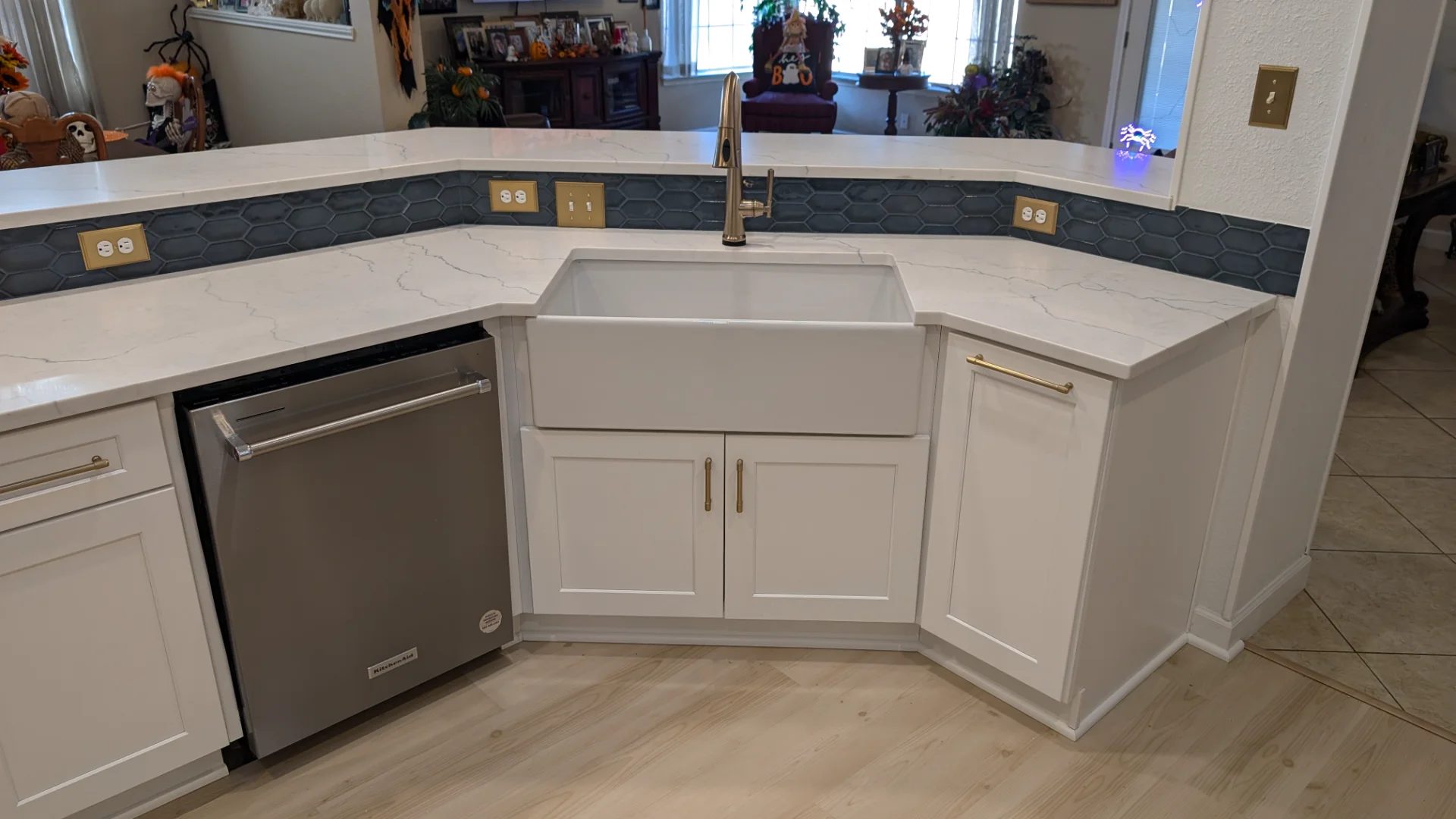 A modern kitchen remodel in Austin, Texas, featuring white shaker-style cabinetry with gold hardware, a blue-grey tile backsplash, white quartz countertops, and stainless steel KitchenAid appliances including a French door refrigerator and a slide-in range. - Detail 3