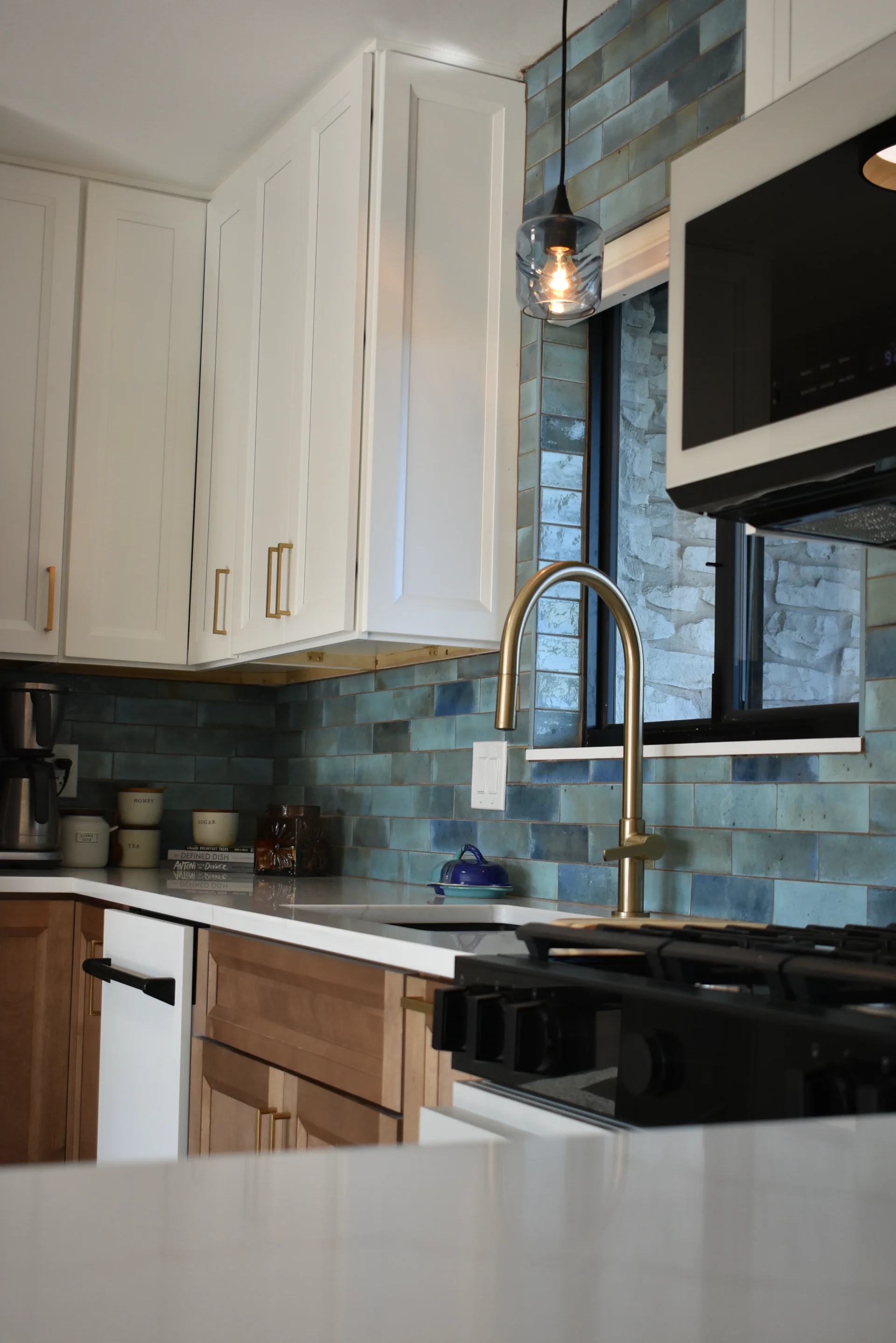 Modern kitchen from New Project in Austin, TX, featuring a bold blue subway tile backsplash, white and wood cabinetry, a large kitchen island with seating, and gold accents. This contemporary design is perfect for homes in West Lake Hills, Dripping Springs, and Tarrytown. - Detail 2