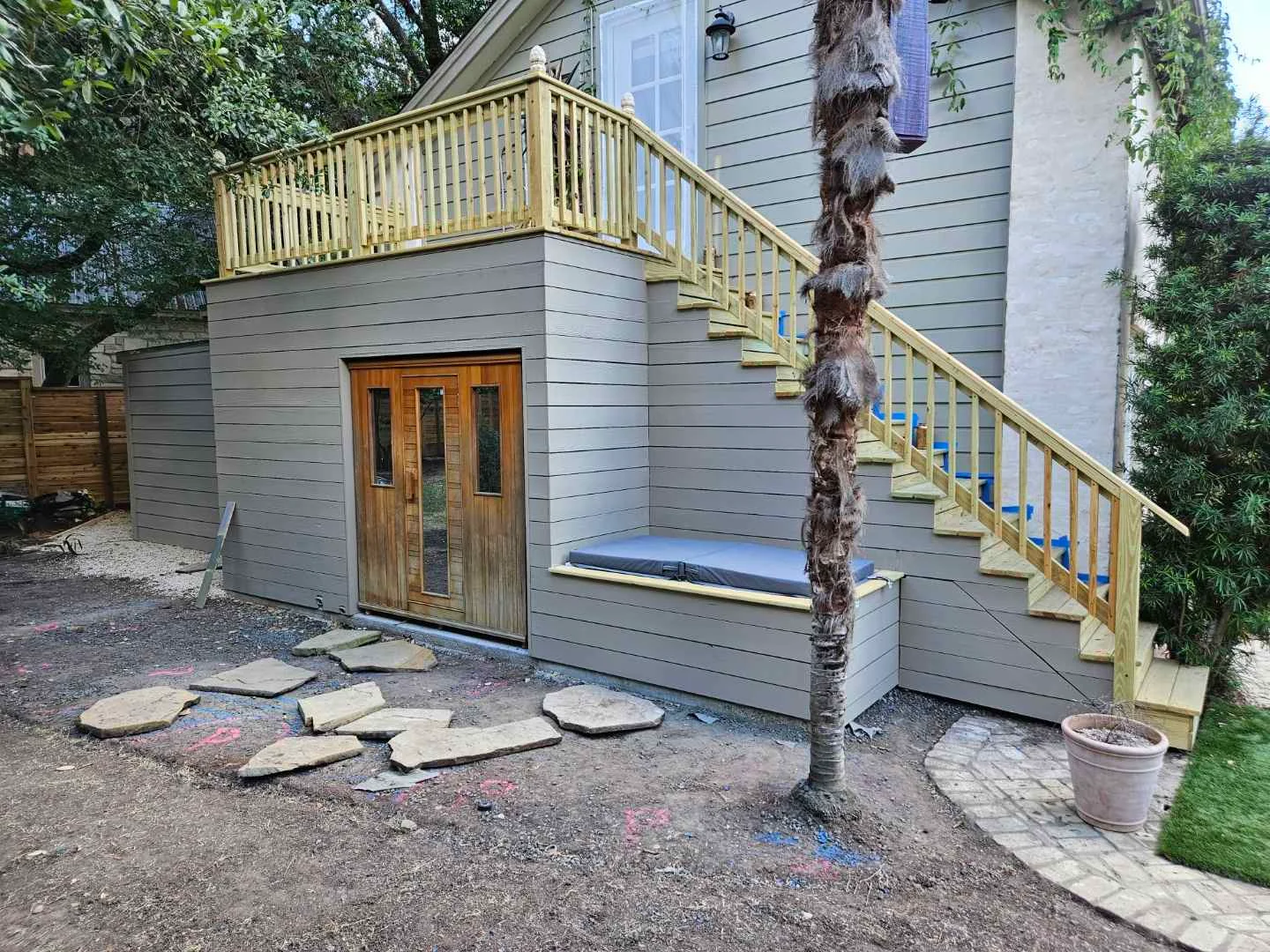 A modern outdoor sauna constructed from warm-toned wood, featuring a central door and two side panels with vertical windows, integrated into the architecture of a home in West Lake Hills, Austin. - Detail 3