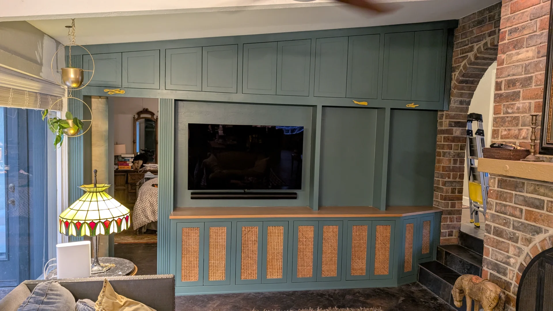 Custom dark teal built-in entertainment center with rattan panel doors and integrated TV niche in a West Lake Hills home. - Detail 2
