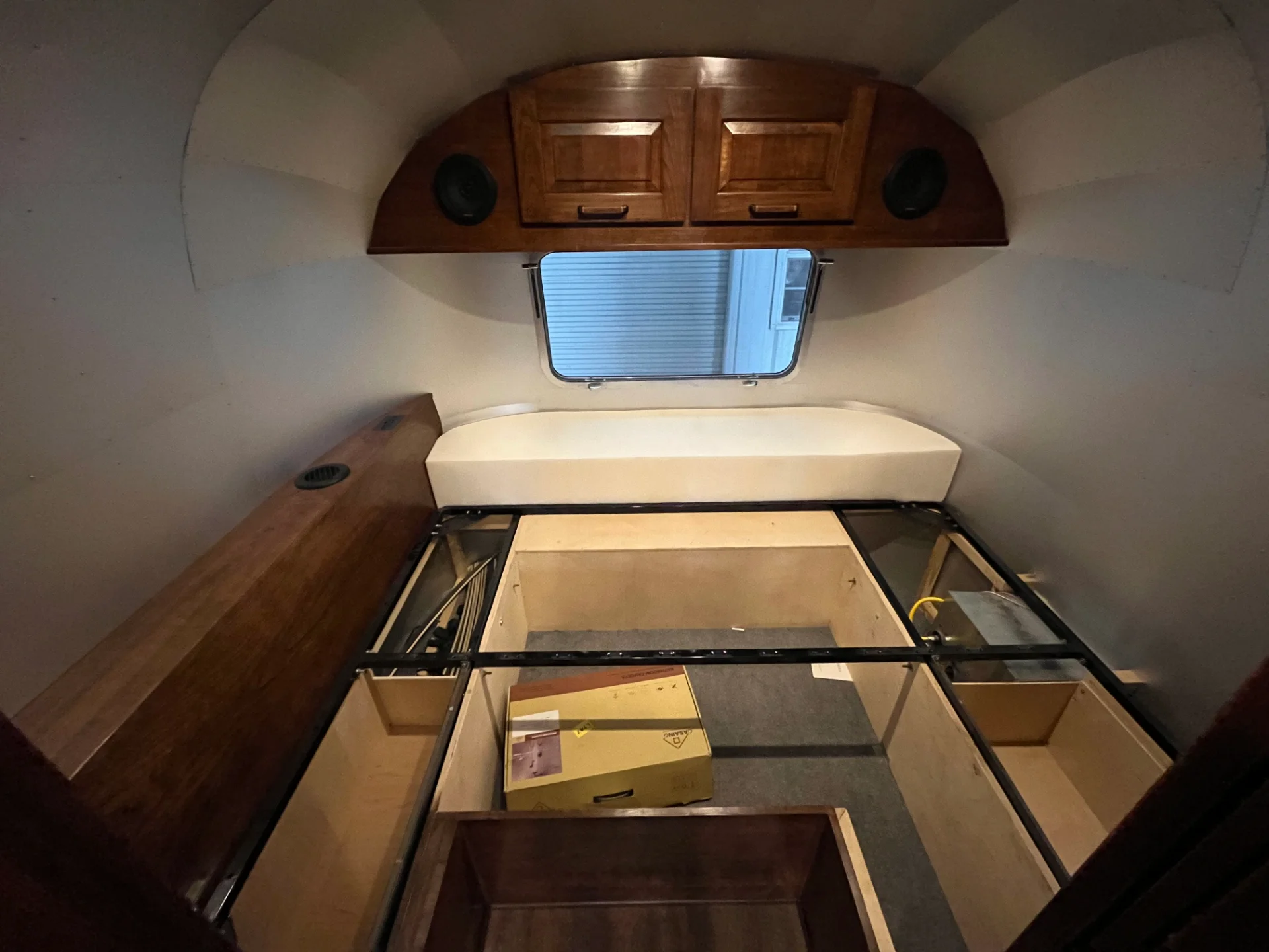 Modern interior of a renovated Airstream featuring custom light-wood cabinetry, a sleek black kitchenette, and wood-style flooring in a New Project located in Austin and the Texas Hill Country. - Detail 6