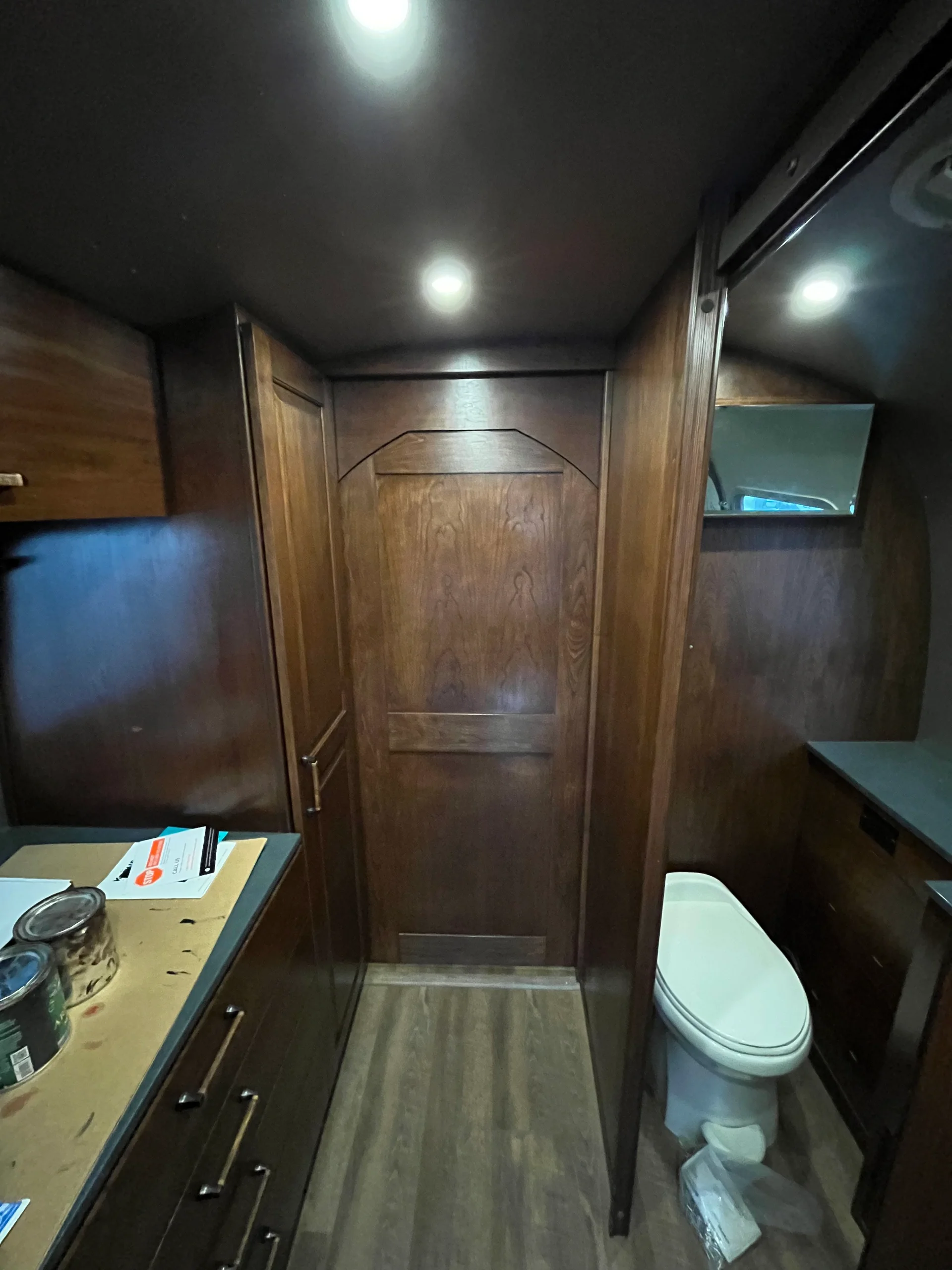 Modern interior of a renovated Airstream featuring custom light-wood cabinetry, a sleek black kitchenette, and wood-style flooring in a New Project located in Austin and the Texas Hill Country. - Detail 8