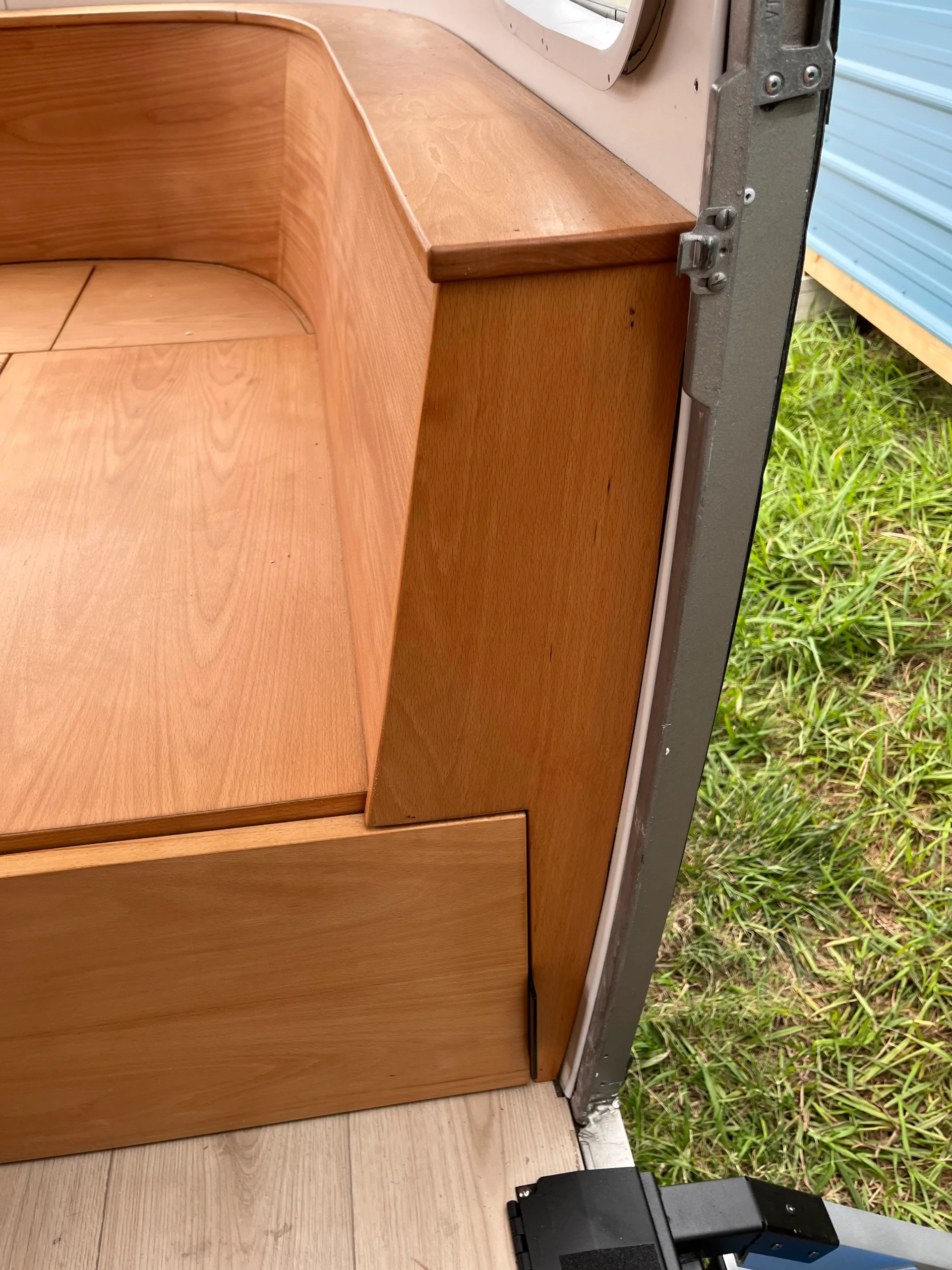 Modern interior of a renovated Airstream featuring custom light-wood cabinetry, a sleek black kitchenette, and wood-style flooring in a New Project located in Austin and the Texas Hill Country. - Detail 21