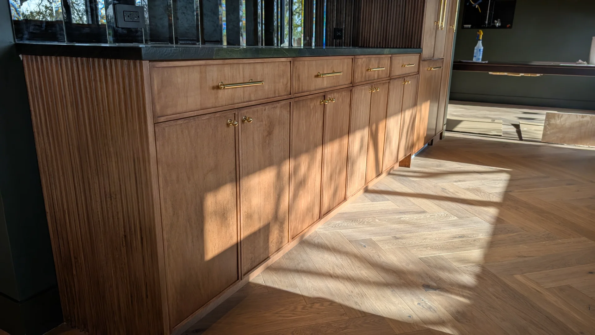 Custom fluted wood cabinetry with brass hardware in a luxury West Lake Hills Austin residence.