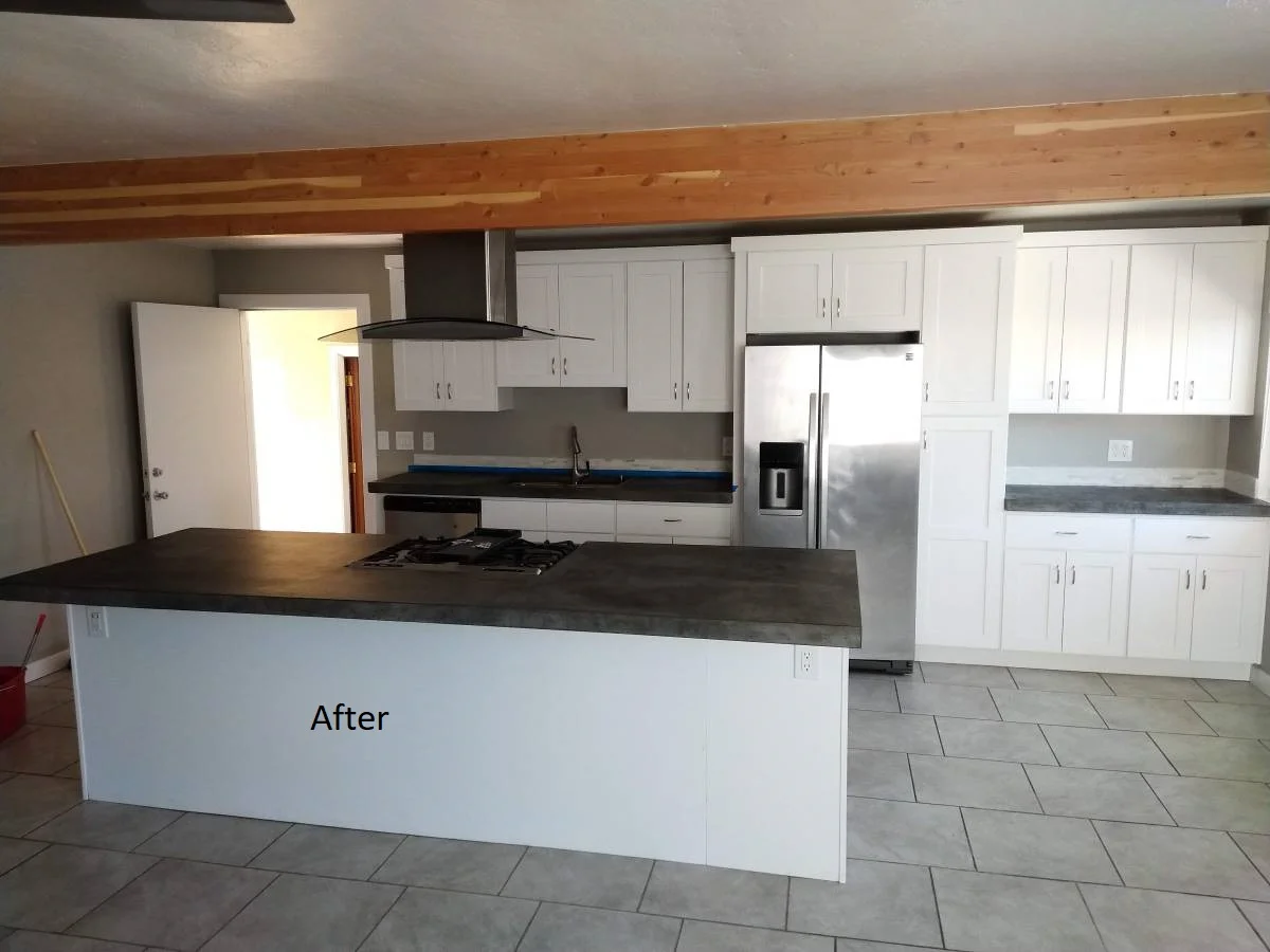 A newly remodeled modern kitchen in Austin featuring white shaker cabinets, dark concrete-style countertops on a large island, and stainless steel appliances, as part of the New Project in West Lake Hills, Dripping Springs, and the Texas Hill Country. - Detail 1