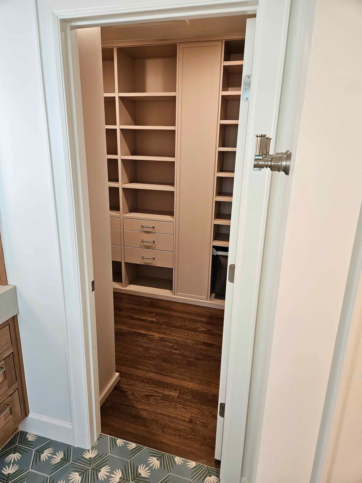 Custom walk-in closet design featuring floor-to-ceiling beige shelving, integrated soft-close drawers, and dedicated shoe storage in a luxury Austin primary suite.