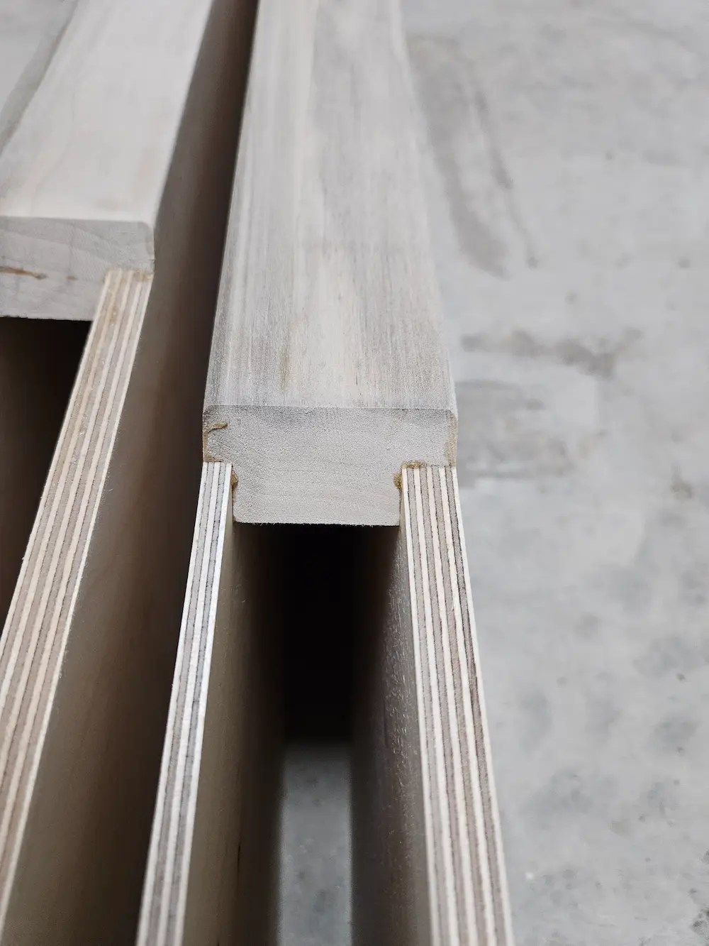 Close-up of premium plywood core and solid wood blocking used in our custom heavy-duty floating shelf and French cleat systems.