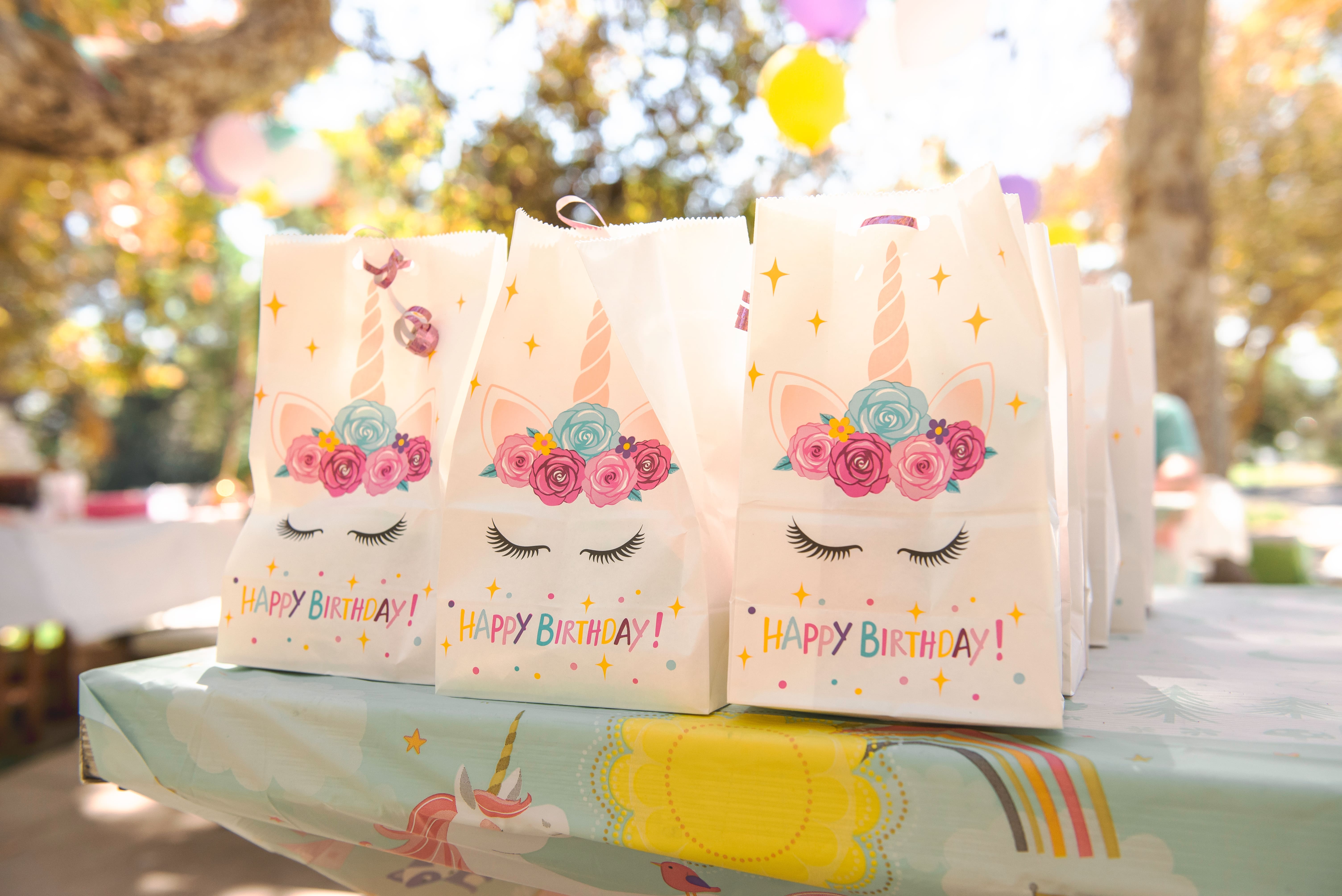 3 Birthday Gift Bags on a birthday-themed table, outdoors