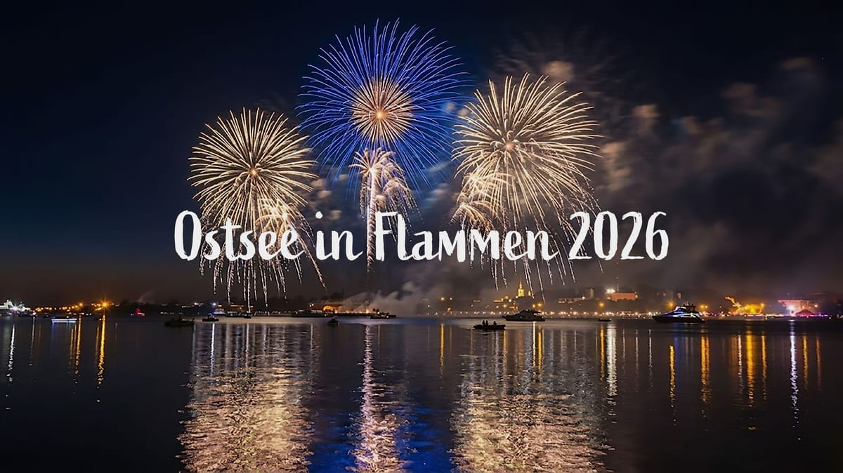 Ein nächtliches Feuerwerk über der Ostsee mit bunten Explosionen am Himmel, die sich im Wasser spiegeln. Im Vordergrund sind Boote zu sehen und im Hintergrund eine beleuchtete Stadtkulisse. Der Text 'Ostsee in Flammen 2026' ist über das Bild gelegt.