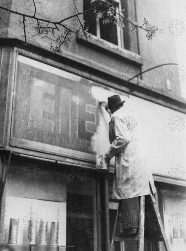 Снятие немецких вывесок над магазином в районе Vinohrady в вечерние часы 4 мая 1945 года.