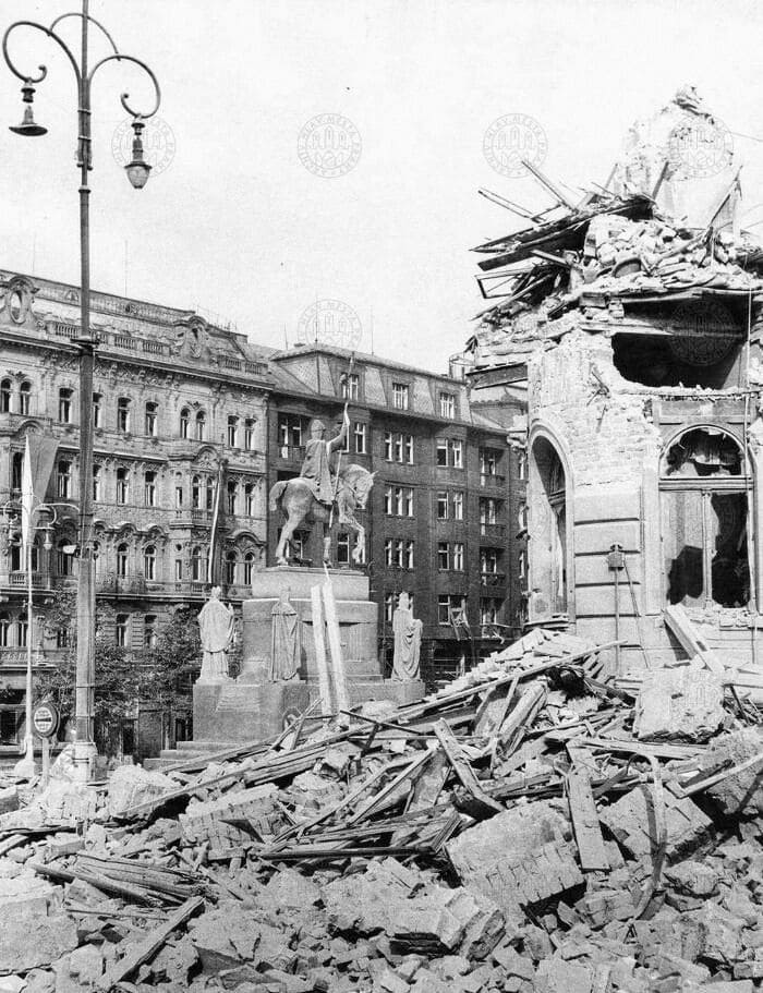 Вид на часть углового дома № 812 в верхней части Вацлавской площади, разрушенного немецкими бомбардировками в мае 1945 года. Видна и статуя св. Вацлава. Май 1945 года.