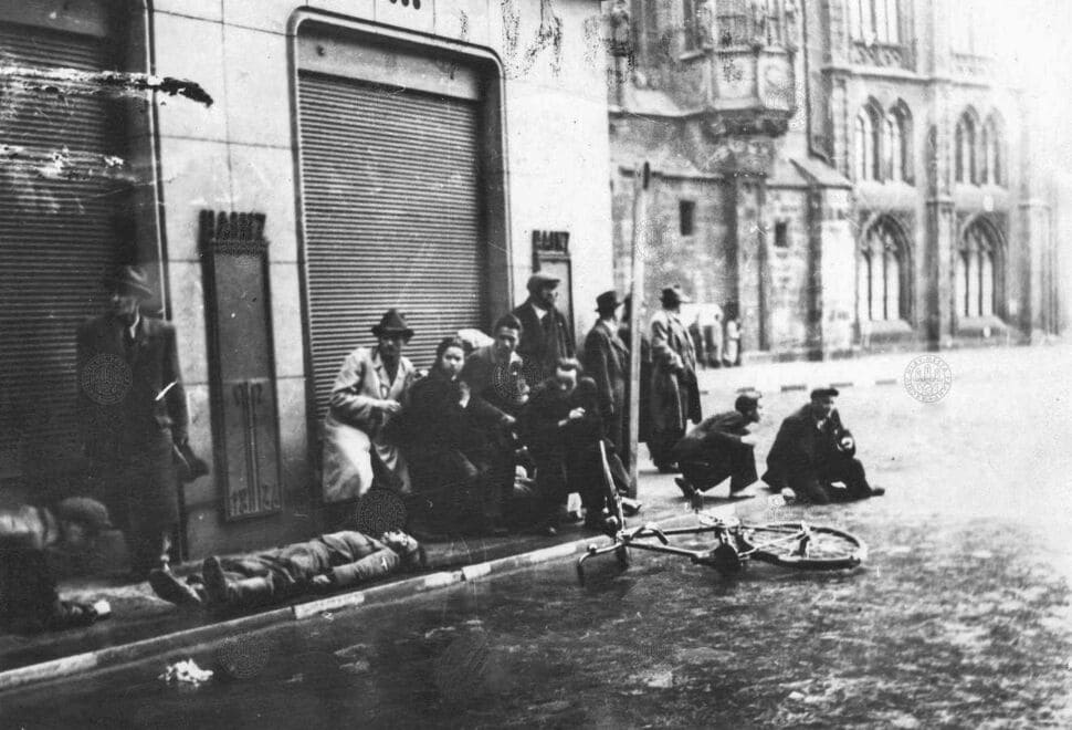 Мертвый немецкий офицер и люди, укрывающиеся от вражеского огня на улице Železná в Праге, 5 мая 1945 года.