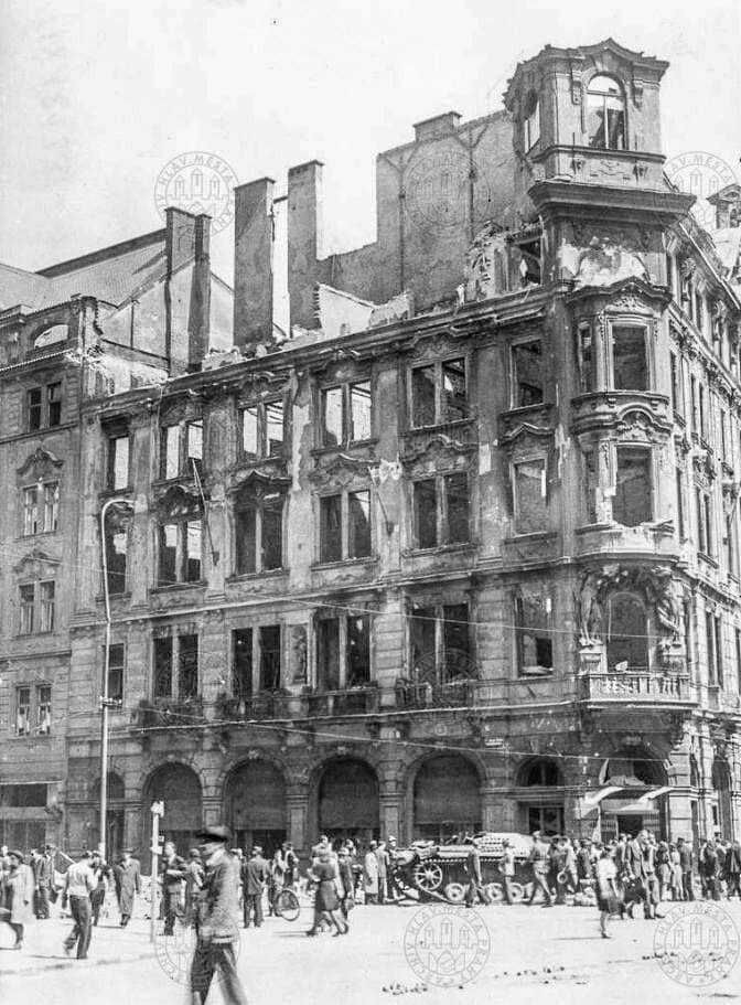 Пражане перед сгоревшим домом № 934 на углу улицы Pařížská и Староместской площади. Перед домом стоит обезвреженная немецкая самоходная артиллерийская установка. Май 1945 года.