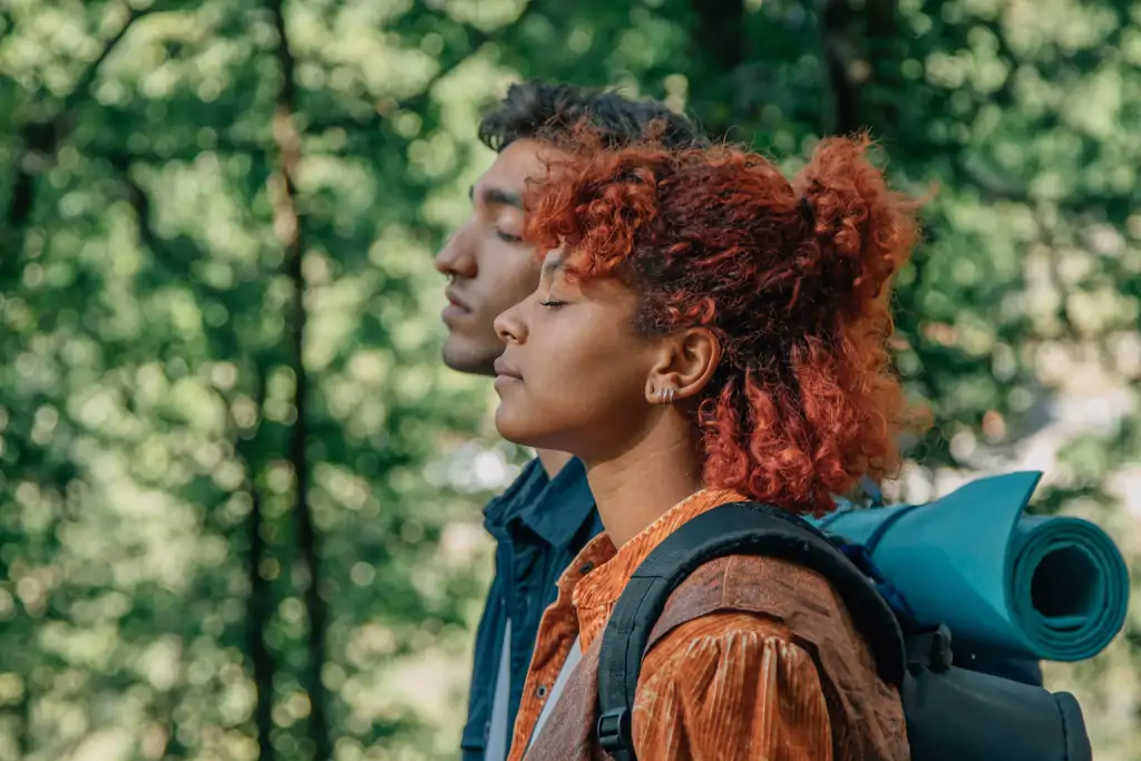 Two people breathing in a forest, depicting forest bathing