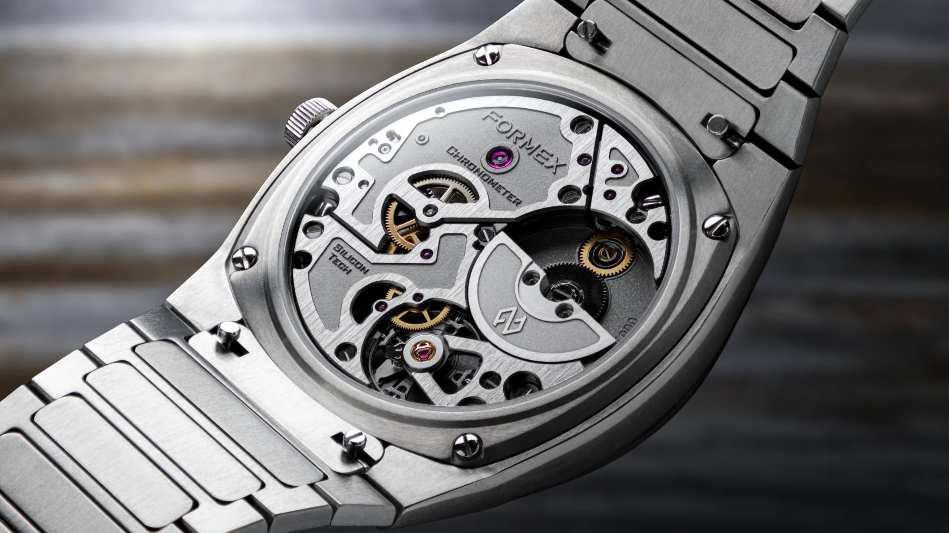 Close-up of a silver Formex watch's open caseback, showing intricate 'CHRONOMETER' movement with gears, rubies, and 'SILICON TECH'.