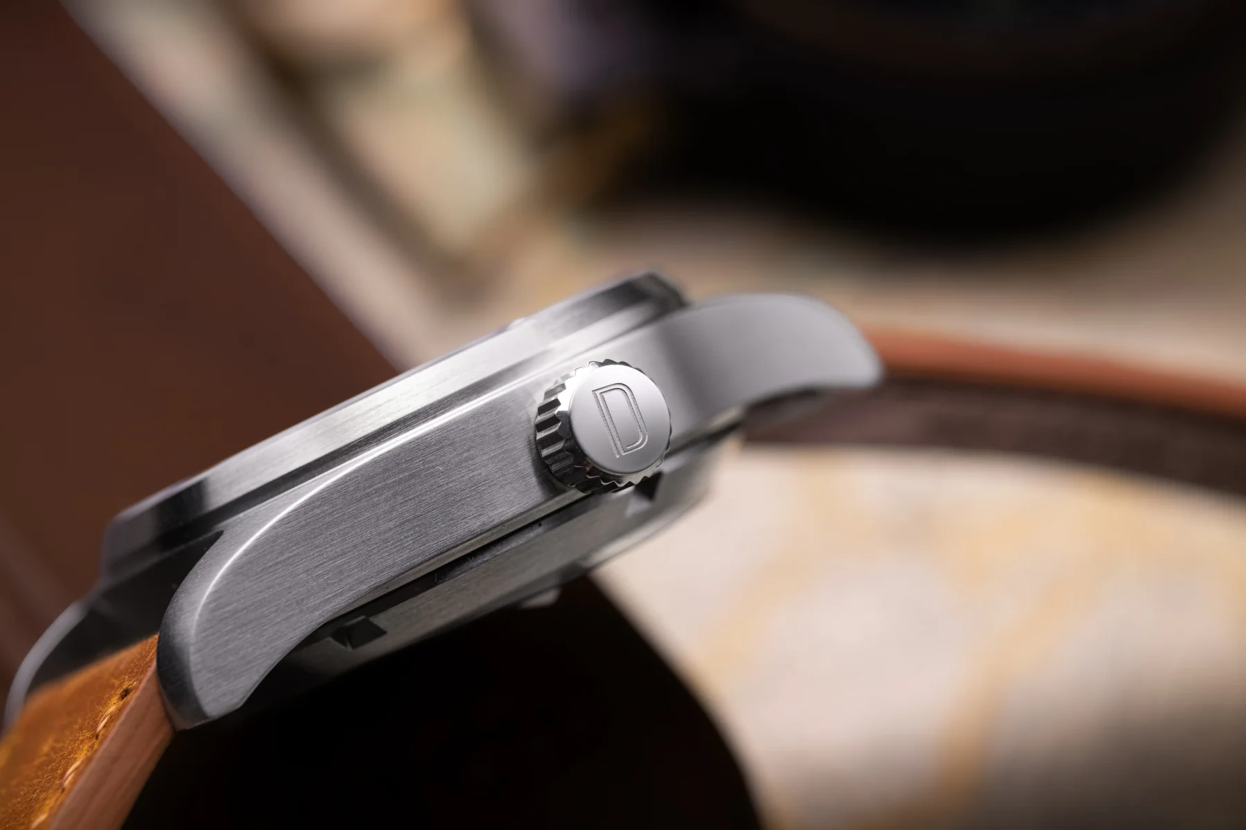 Close-up of Dasher Scout field watch side profile, showing brushed steel case, crown with