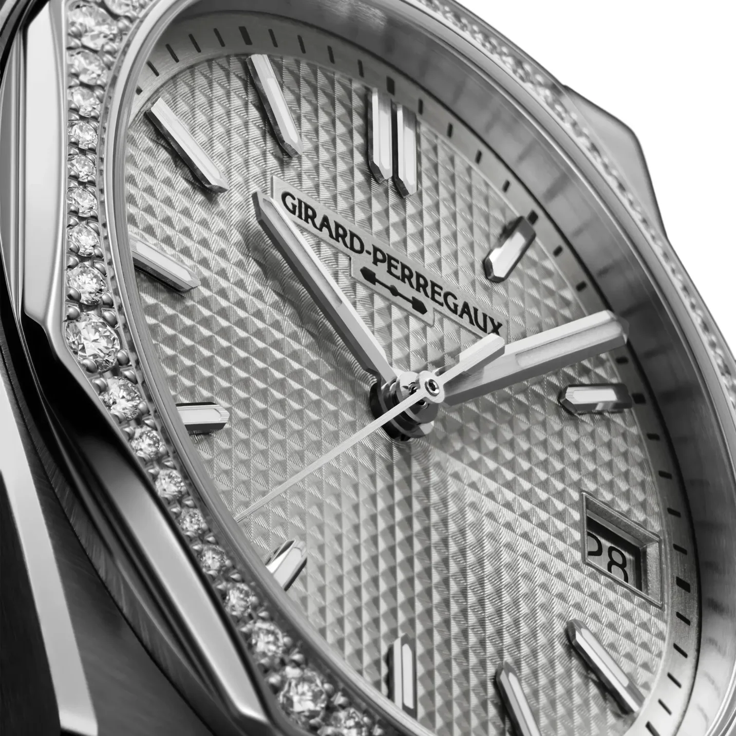 Close-up of a Girard-Perregaux watch: diamond-encrusted bezel, geometric textured dial, metallic hands, date 28.