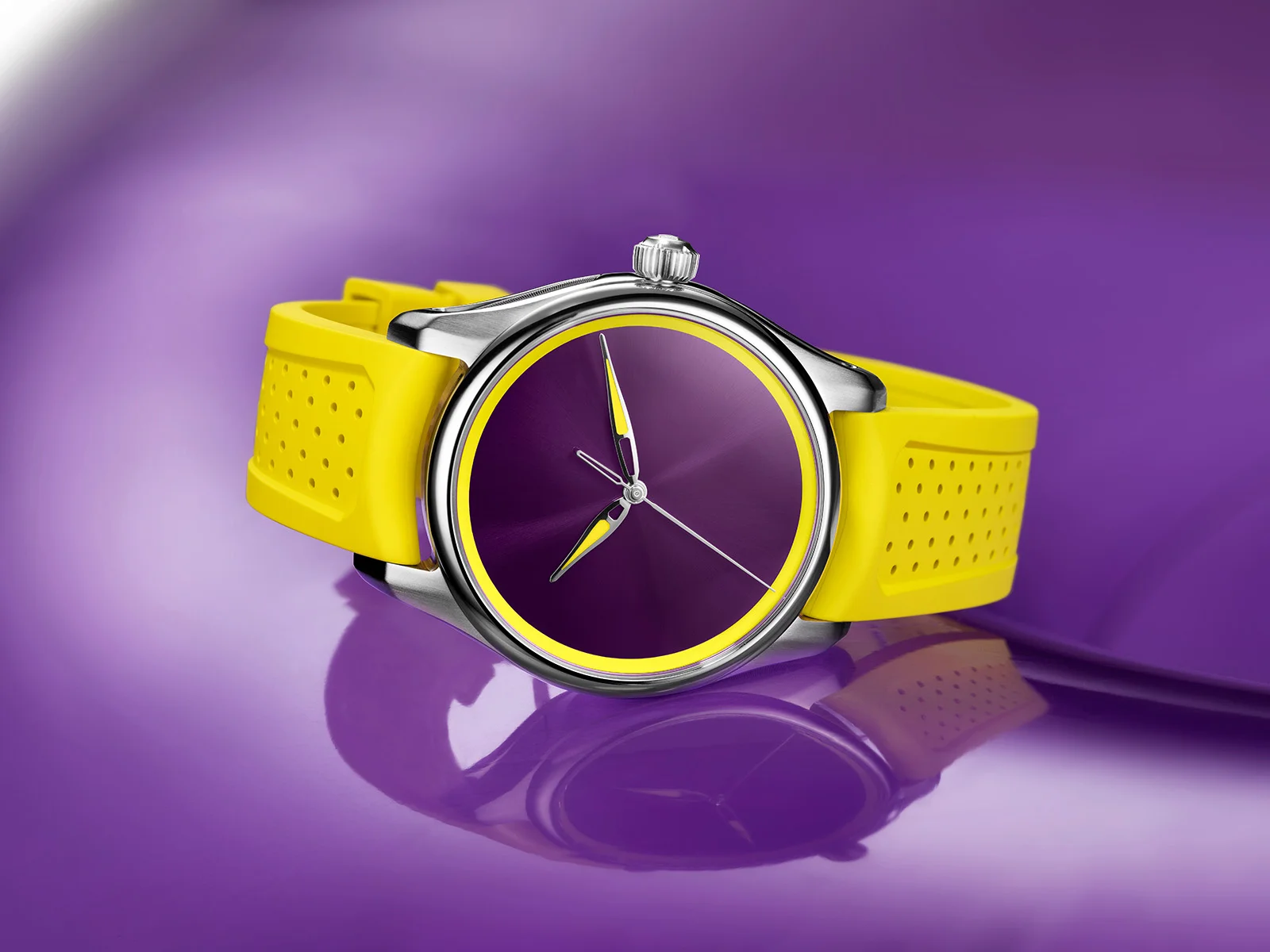 Silver watch with deep purple dial, yellow hands, and perforated yellow rubber strap, resting on a reflective purple surface.