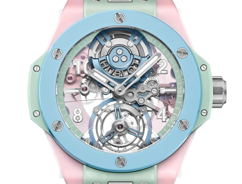 Hublot Big Bang Unico watch with pastel blue bezel, skeleton dial, visible movement, and pink & green strap.