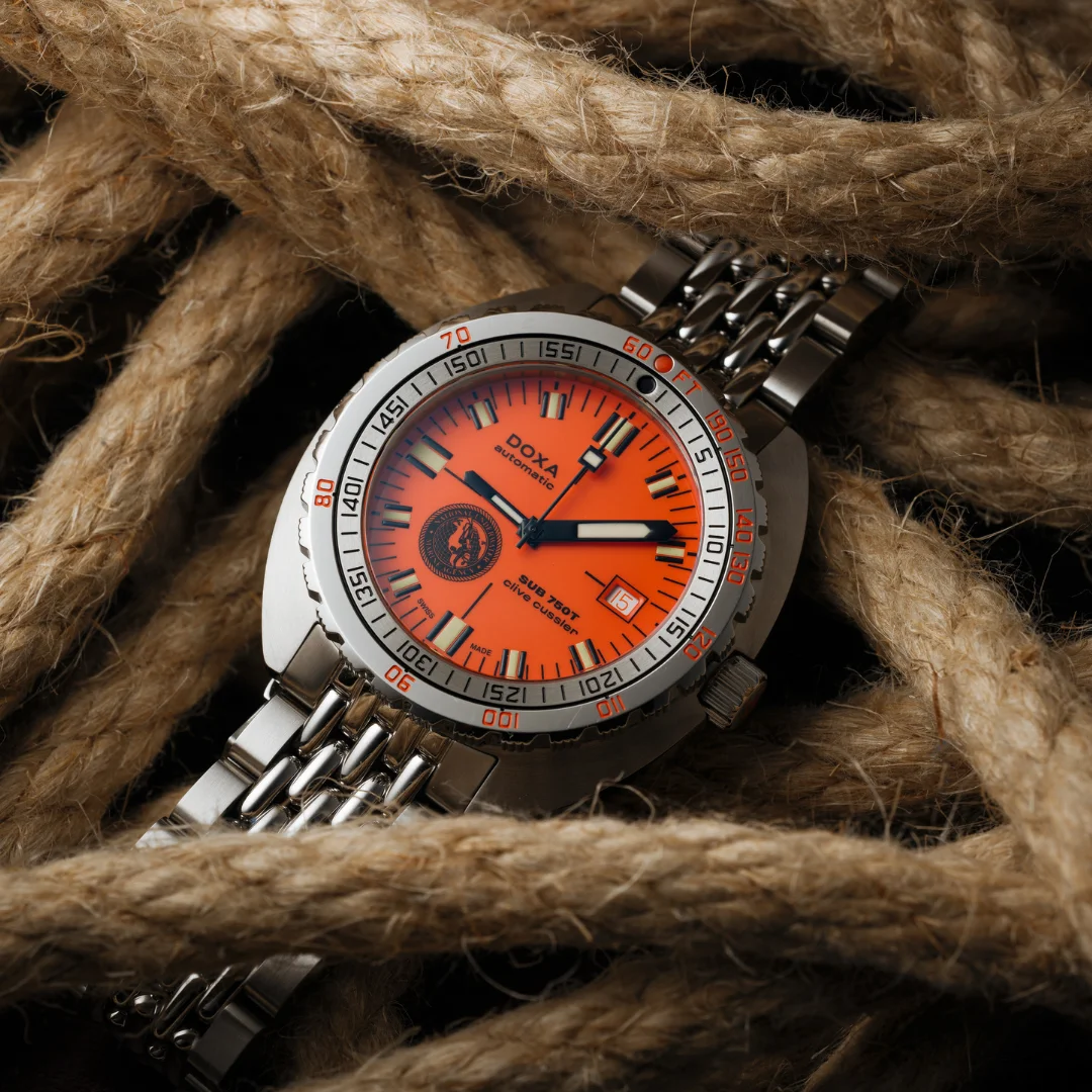 DOXA SUB 750T Clive Cussler watch: orange dial, steel bracelet, resting on thick nautical rope.