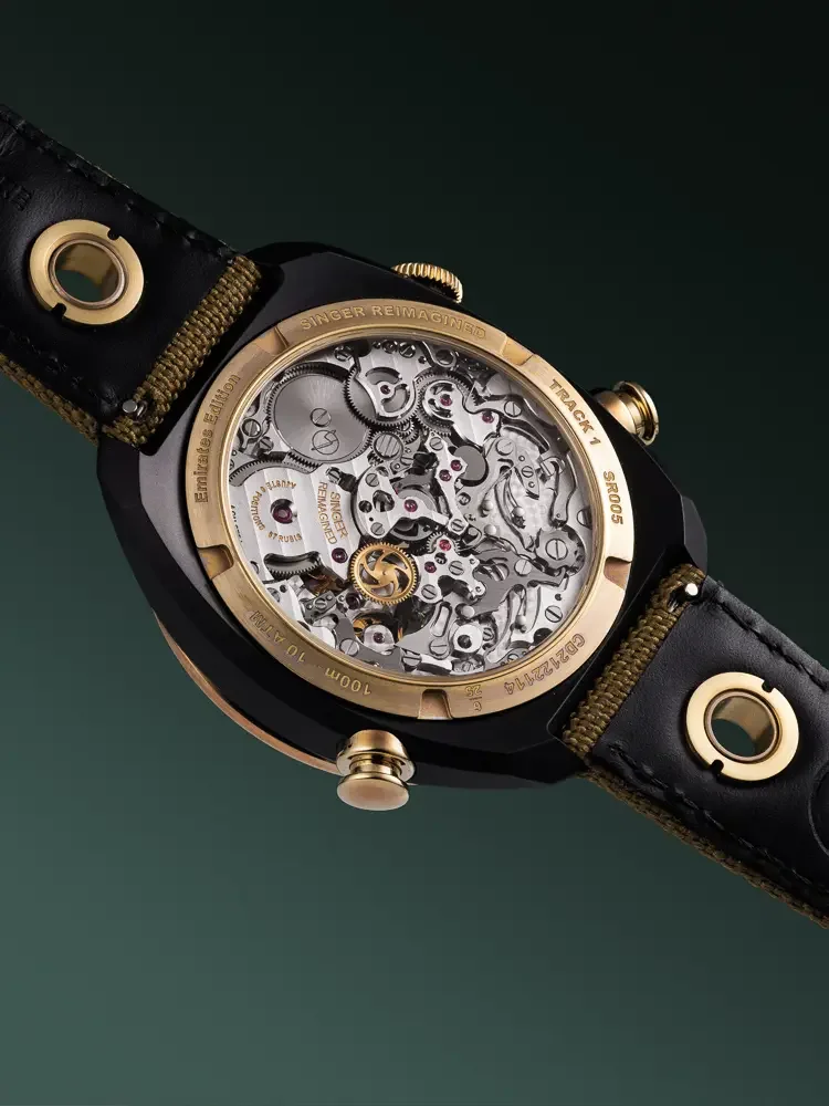 Singer Reimagined Track 1 Emirates watch back on dark green. Gold-trimmed transparent caseback reveals complex movement.