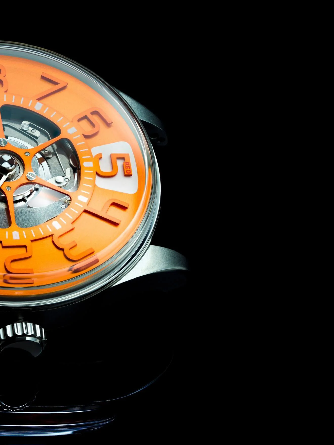 Close-up of a modern luxury watch with a vibrant orange dial, exposed mechanical movement, and white numerals on black.