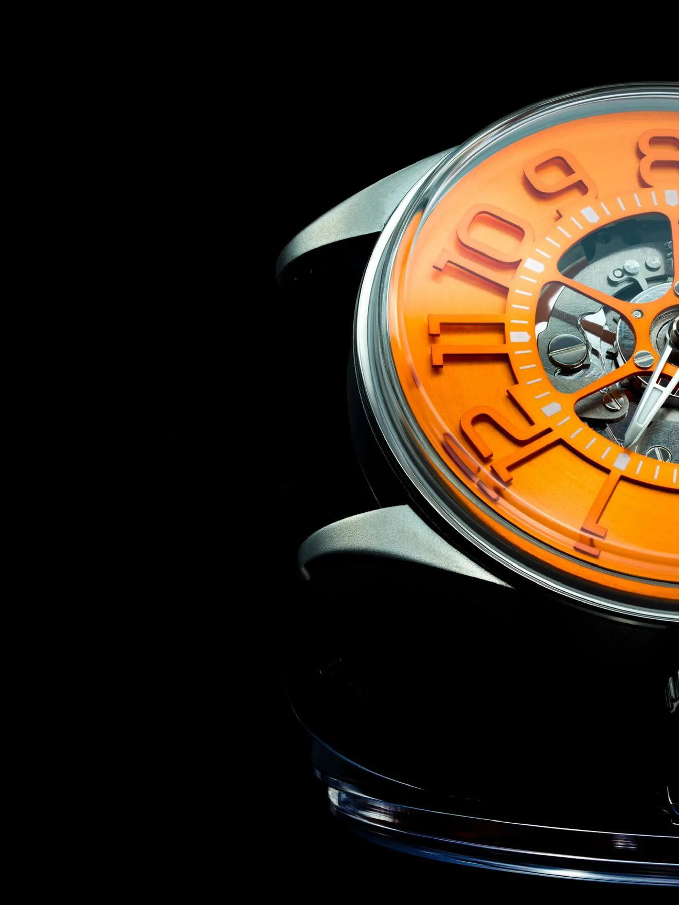 Close-up of a luxury watch featuring a bold orange open-worked dial, exposing its mechanical movement. Metallic case on black background.