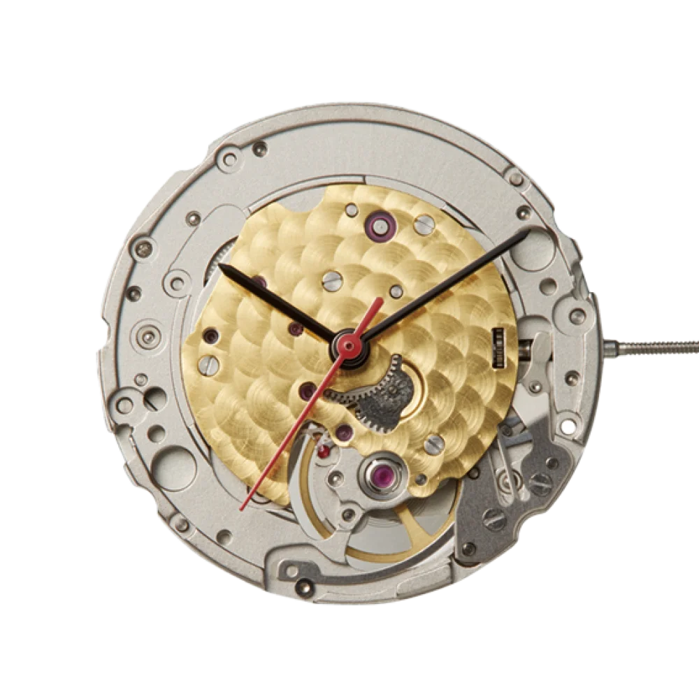 Watch movement showing a gold guilloché rotor, silver plates, exposed gears, ruby jewels, and black/red hands.