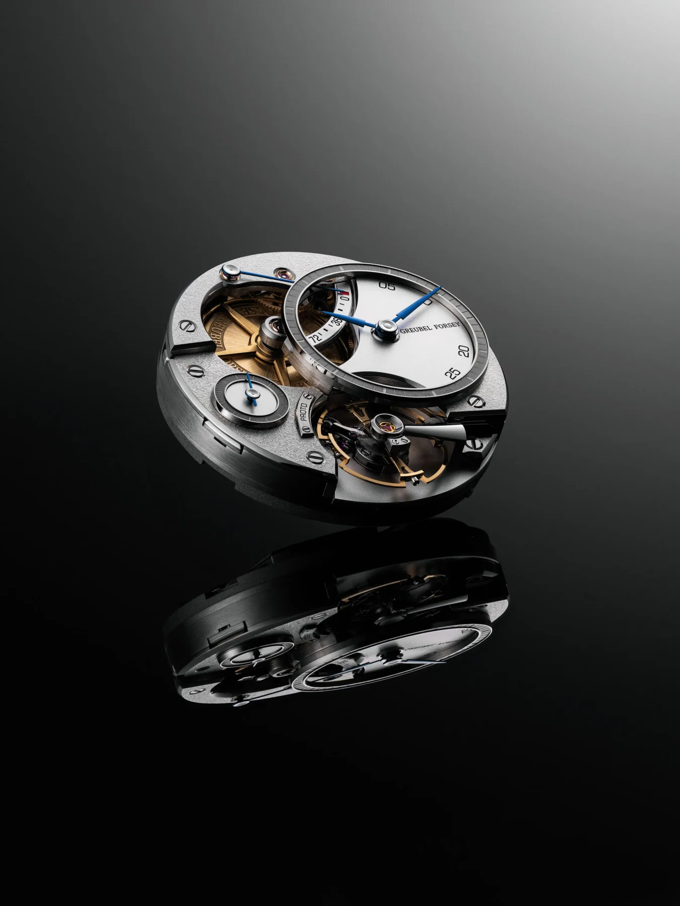Exposed luxury Greubel Forsey watch movement with gold gears, blue hands, and intricate mechanics, reflected on black.