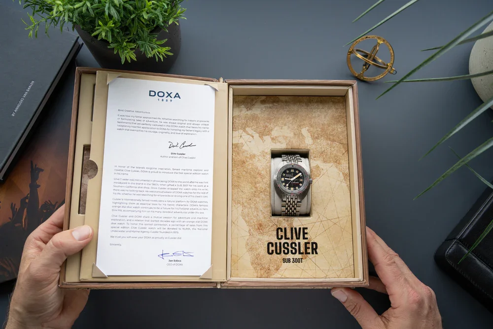 Doxa Sub 300T Clive Cussler silver dive watch, black dial, beads of rice bracelet in its wooden box with letter.
