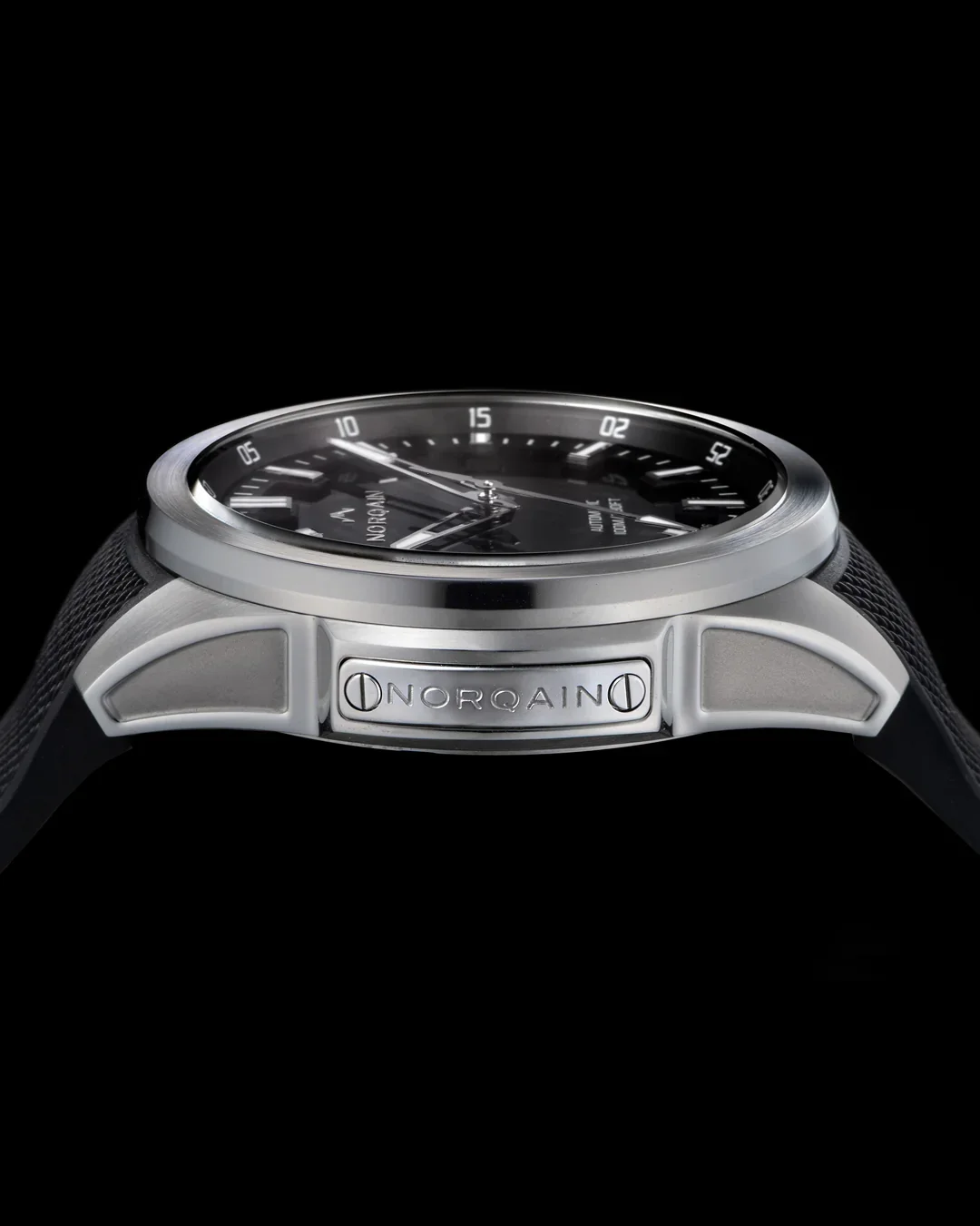 Silver Norqain watch with black dial and textured strap, side plaque engraved 'NORQAIN', on a black background.