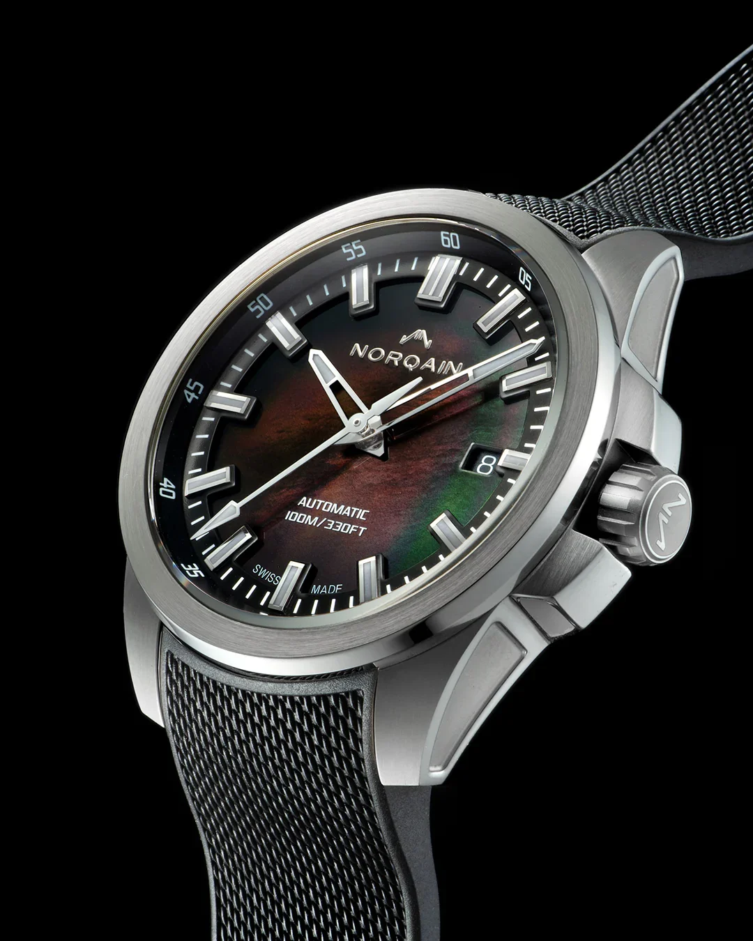 Norqain watch with brushed steel case, iridescent mother-of-pearl dial, black textured strap, on black background.