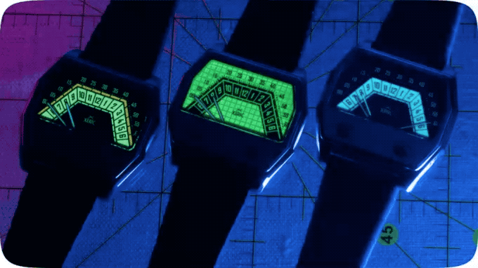 Three retro-futuristic digital watches with glowing yellow-green, green, and blue displays on a dark grid.