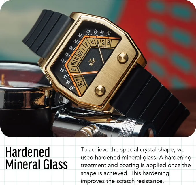 Angular gold Xeric watch with black geometric dial & ribbed strap, on shiny metal objects. Blurred colorful background.