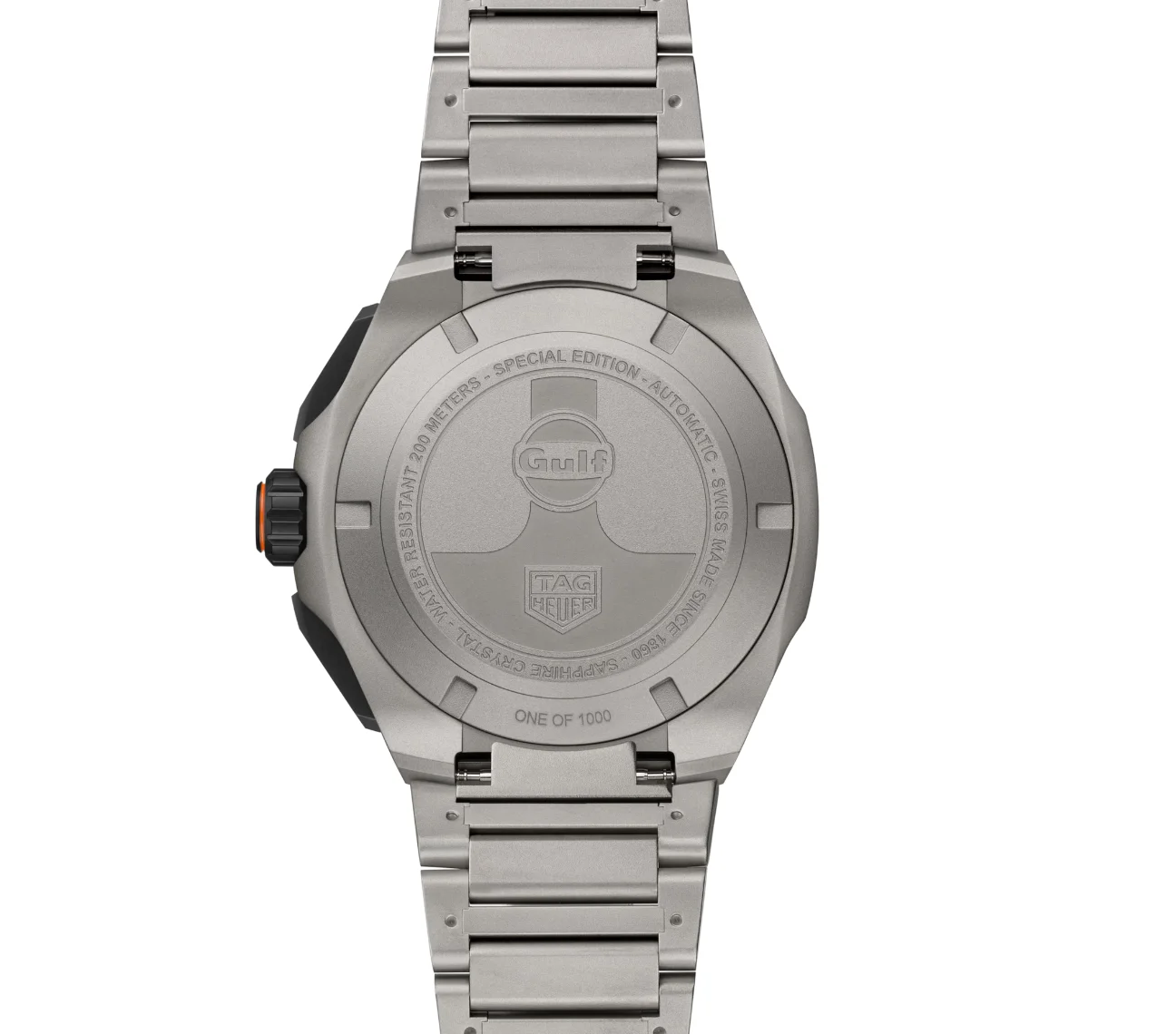 Back of a silver TAG Heuer watch on metal bracelet. Engraved Gulf logo, Special Edition, and 'ONE OF 1000'. Orange crown.