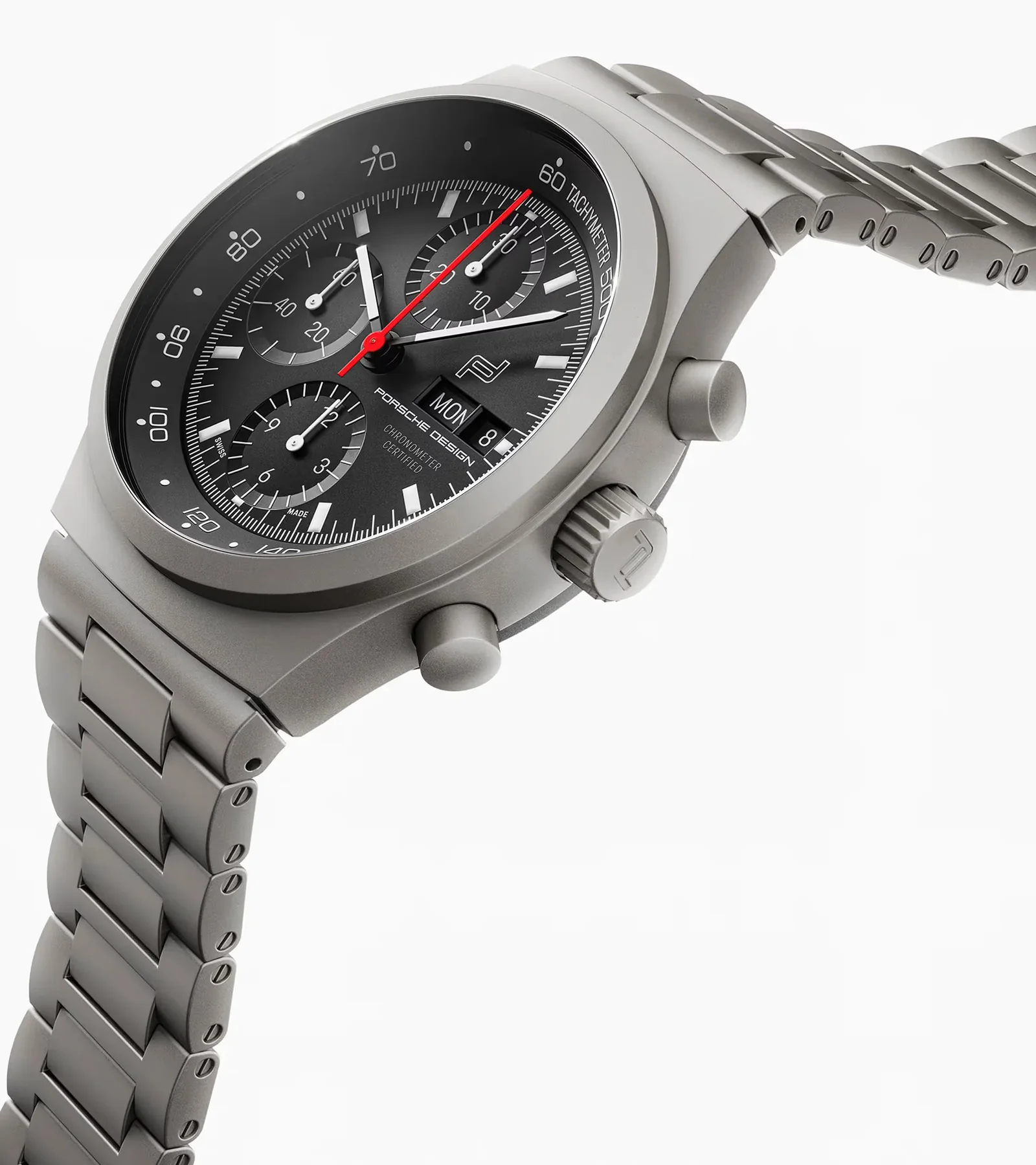 Matte grey titanium Porsche Design chronograph watch with black dial, red hand, day/date, and link bracelet on white.