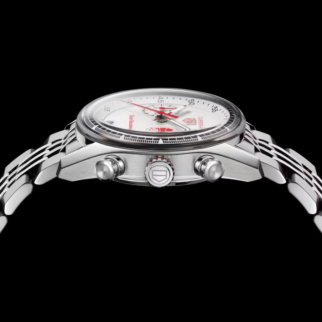 Side view of a silver TAG Heuer Carrera chronograph watch with white dial, red accents, and metal bracelet on black.