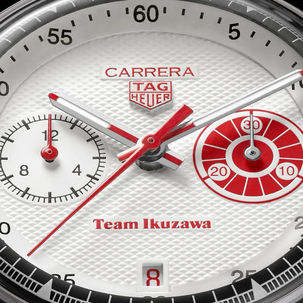 White Tag Heuer Carrera Team Ikuzawa watch dial with textured pattern. Red logo, text, accents, bullseye sub-dial, date '8'.
