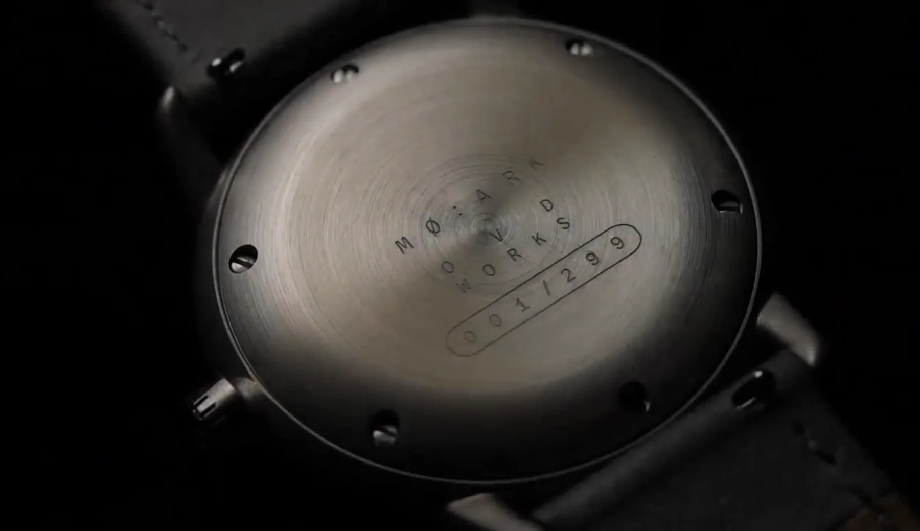 Close-up of a brushed metal watch case back engraved 