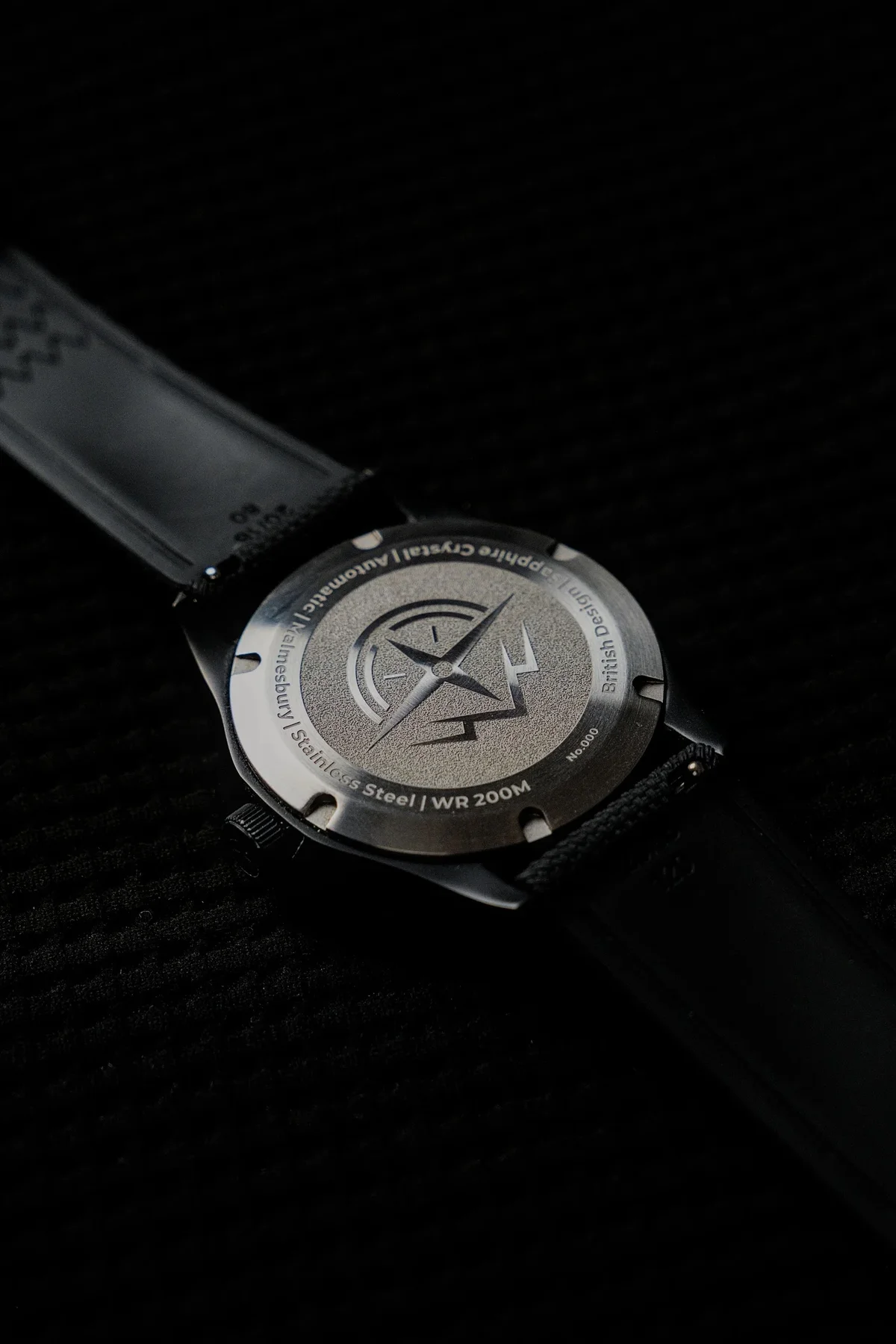 Rear view of a luxury watch. Stainless steel caseback with engraved compass logo, 