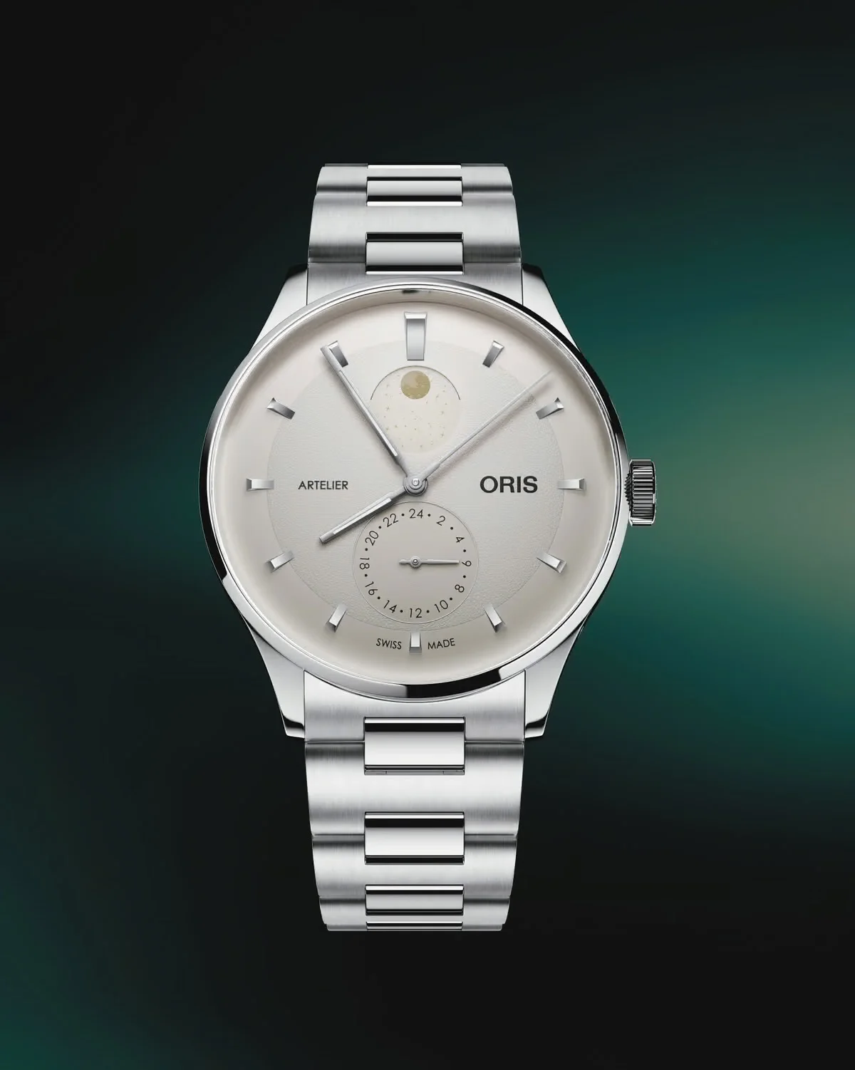 Oris Artelier moon phase watch with silver dial, 24-hour sub-dial, and steel bracelet on a dark teal background.
