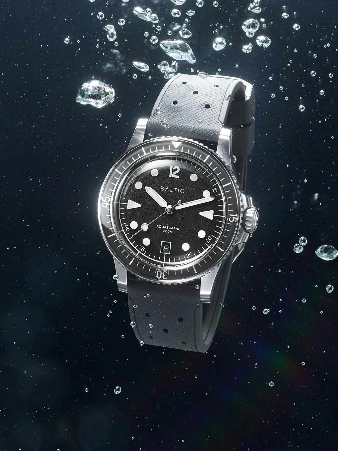 Baltic Aquascaphe 200M dive watch with blue dial, silver case, and grey rubber strap, surrounded by bubbles underwater.