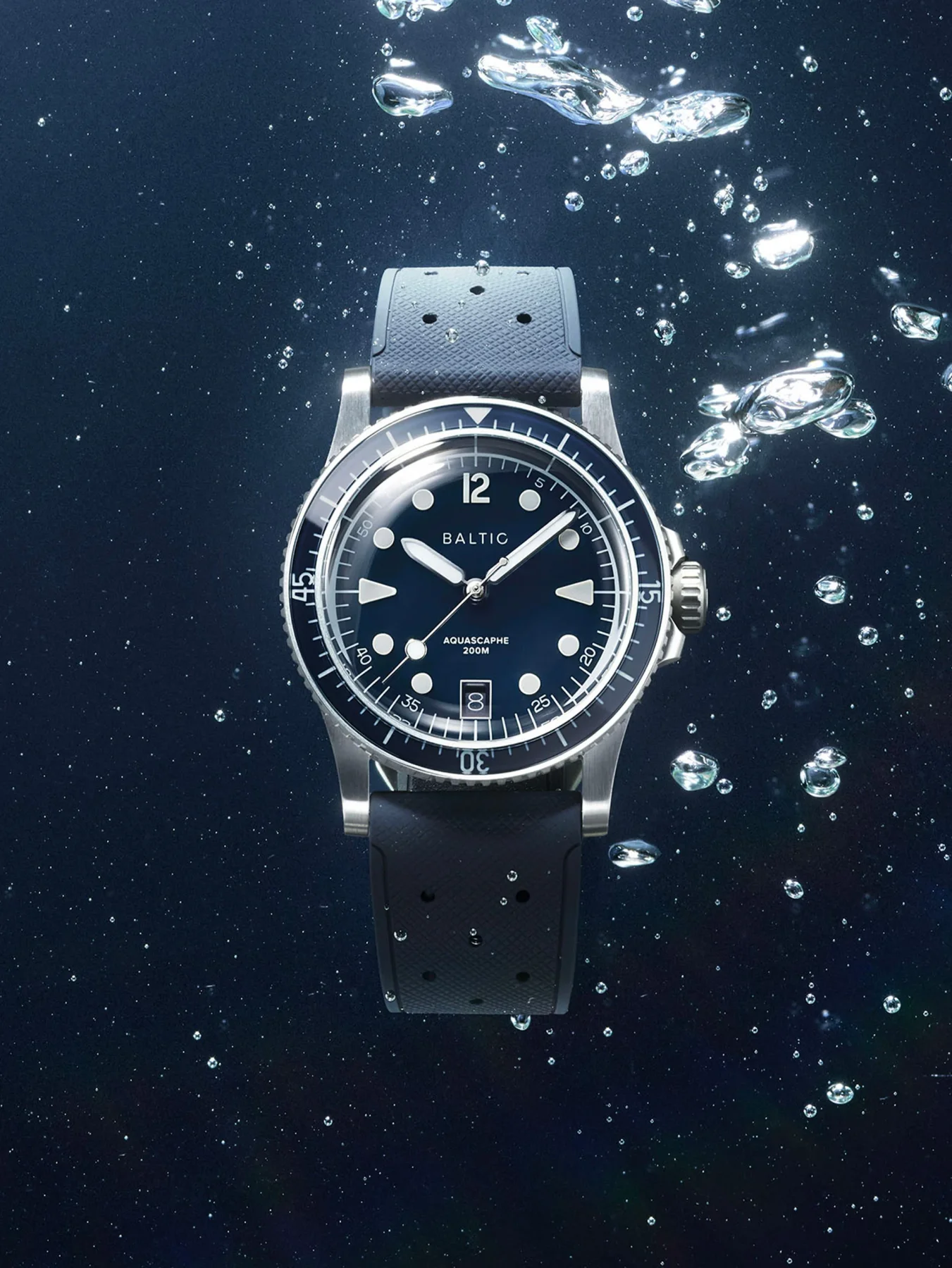 Baltic Aquascaphe dive watch with dark blue dial, black rubber strap, submerged in water with many bubbles.