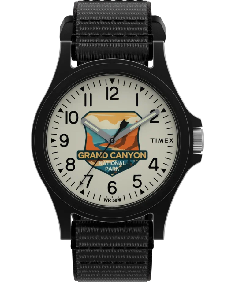 Timex Grand Canyon watch. Black case, fabric strap. Cream dial with Grand Canyon National Park emblem, Arabic numerals, silver crown.
