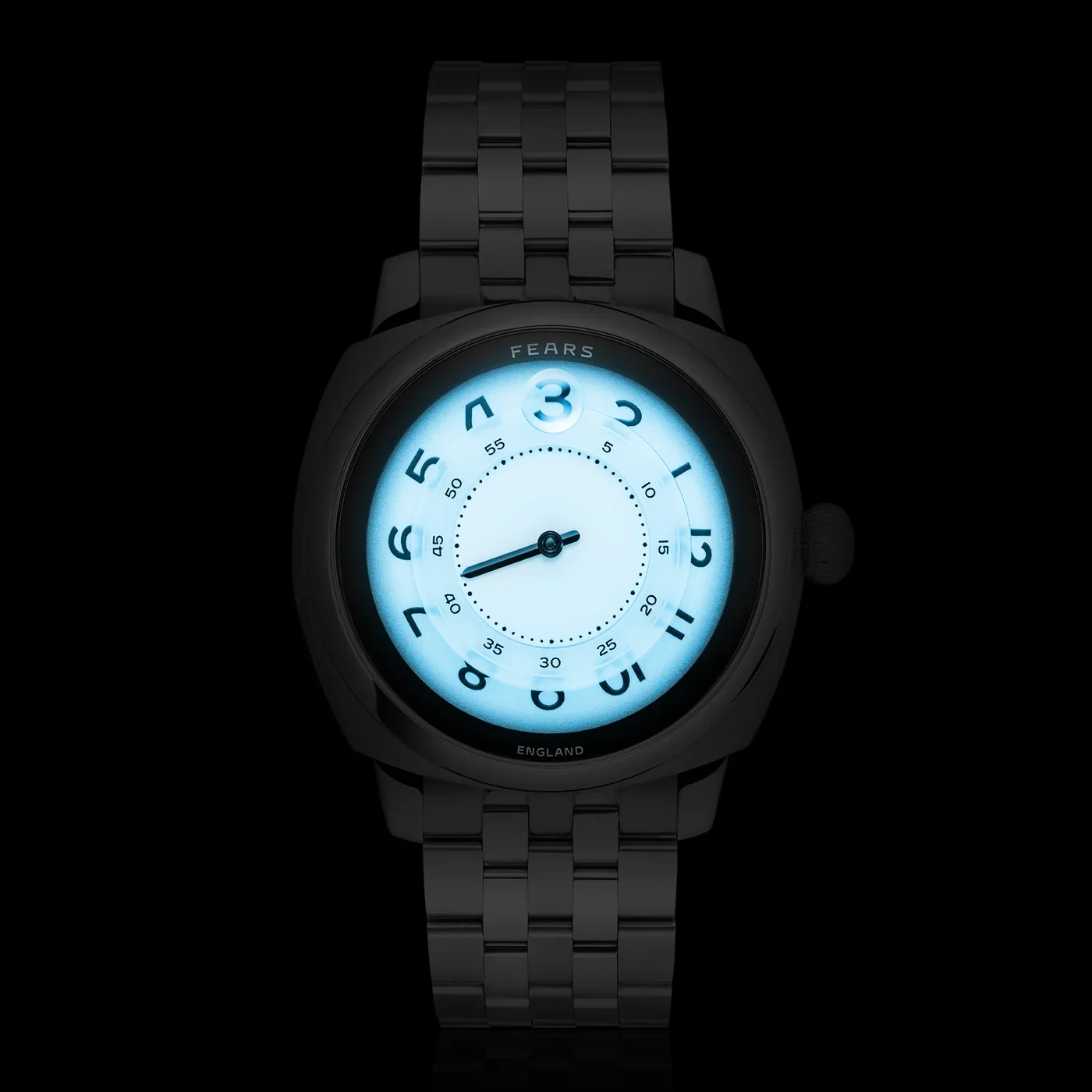 Fears black metal watch with a luminous blue-white dial, glowing brightly against a dark background.