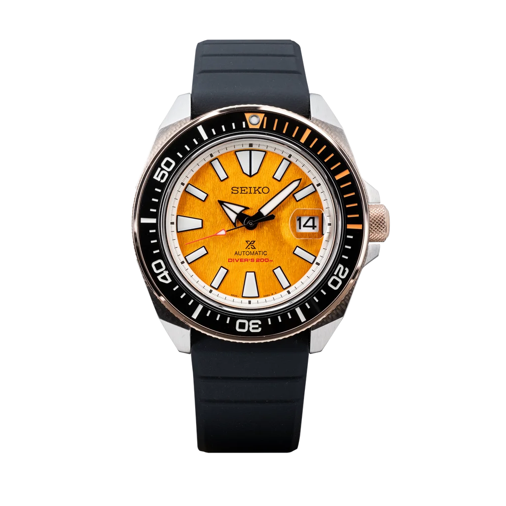 Seiko Prospex diver watch with textured orange dial, black/rose gold bezel, steel case, and black rubber strap.