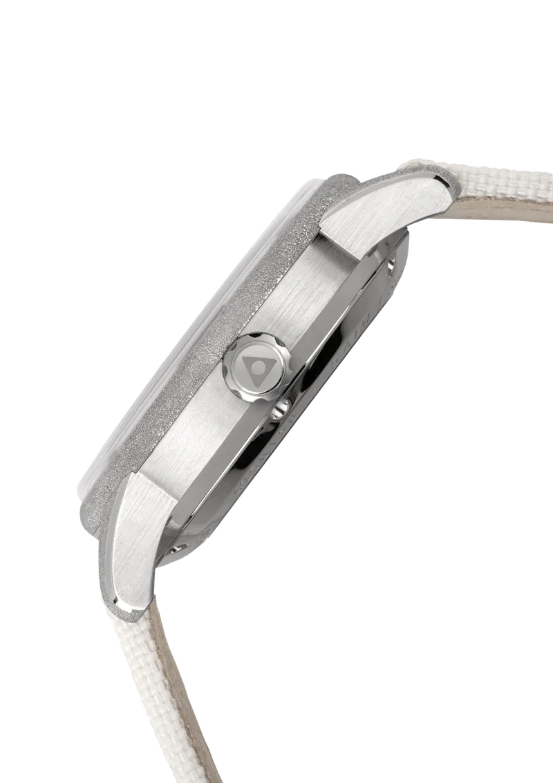 Steel watch, side profile: frosted bezel, brushed case, crown with triangle logo, light fabric strap.