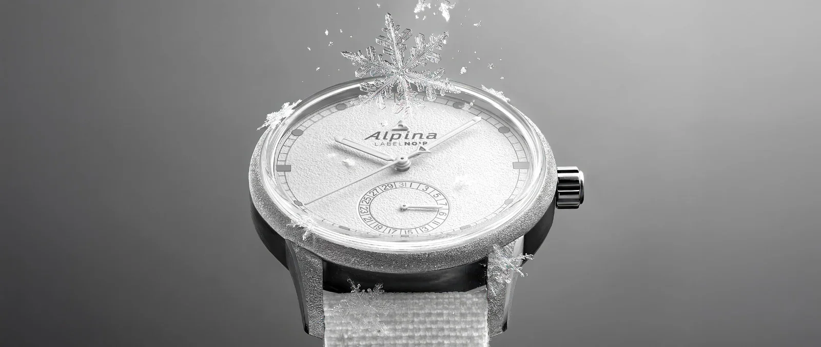 Silver Alpina Label No.9 watch with frosty white dial, date sub-dial, and white strap, covered in ice & snowflakes.