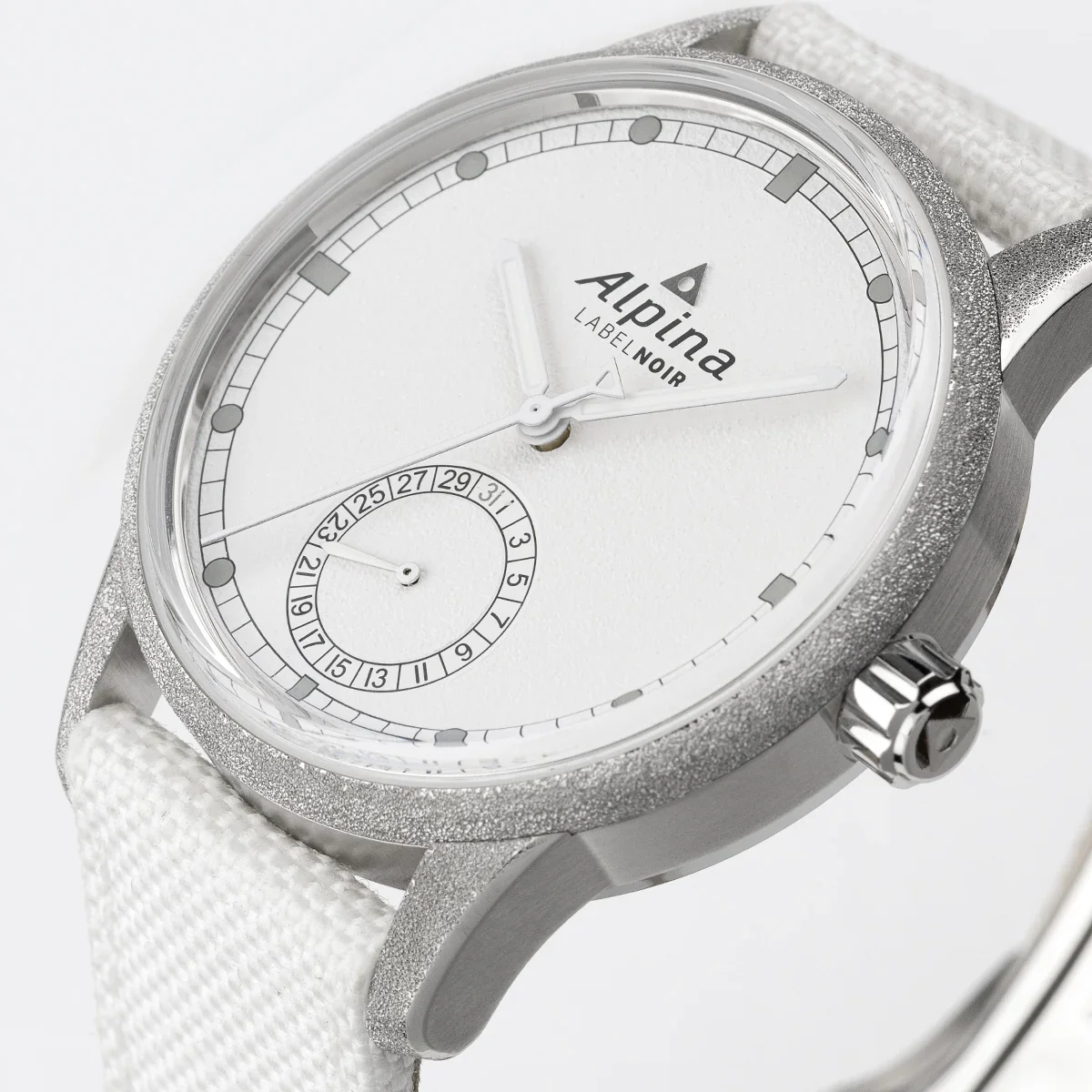 Angled close-up: Alpina Label Noir watch with frosted silver case, white textured dial, date sub-dial, white textile strap.