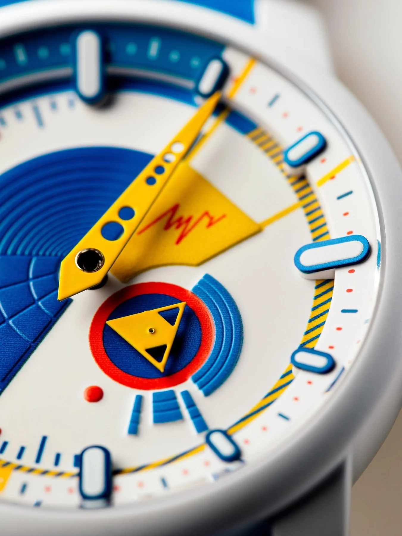 Close-up of a Luch Twist watch dial. White dial with a single yellow hand, blue textures, red accents, and unique hour markers.